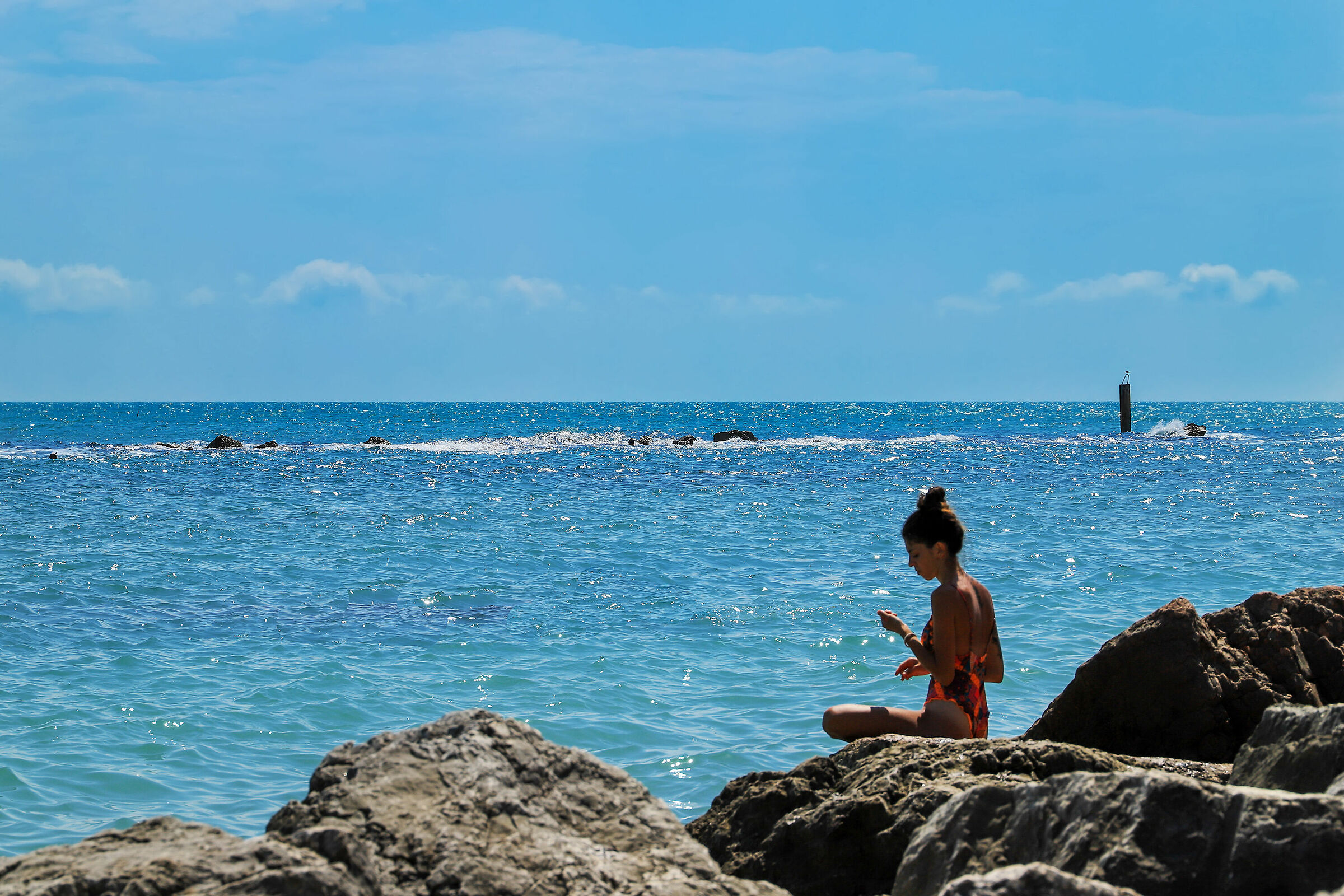 La Sirenetta annoiata sulla roccia aspetta