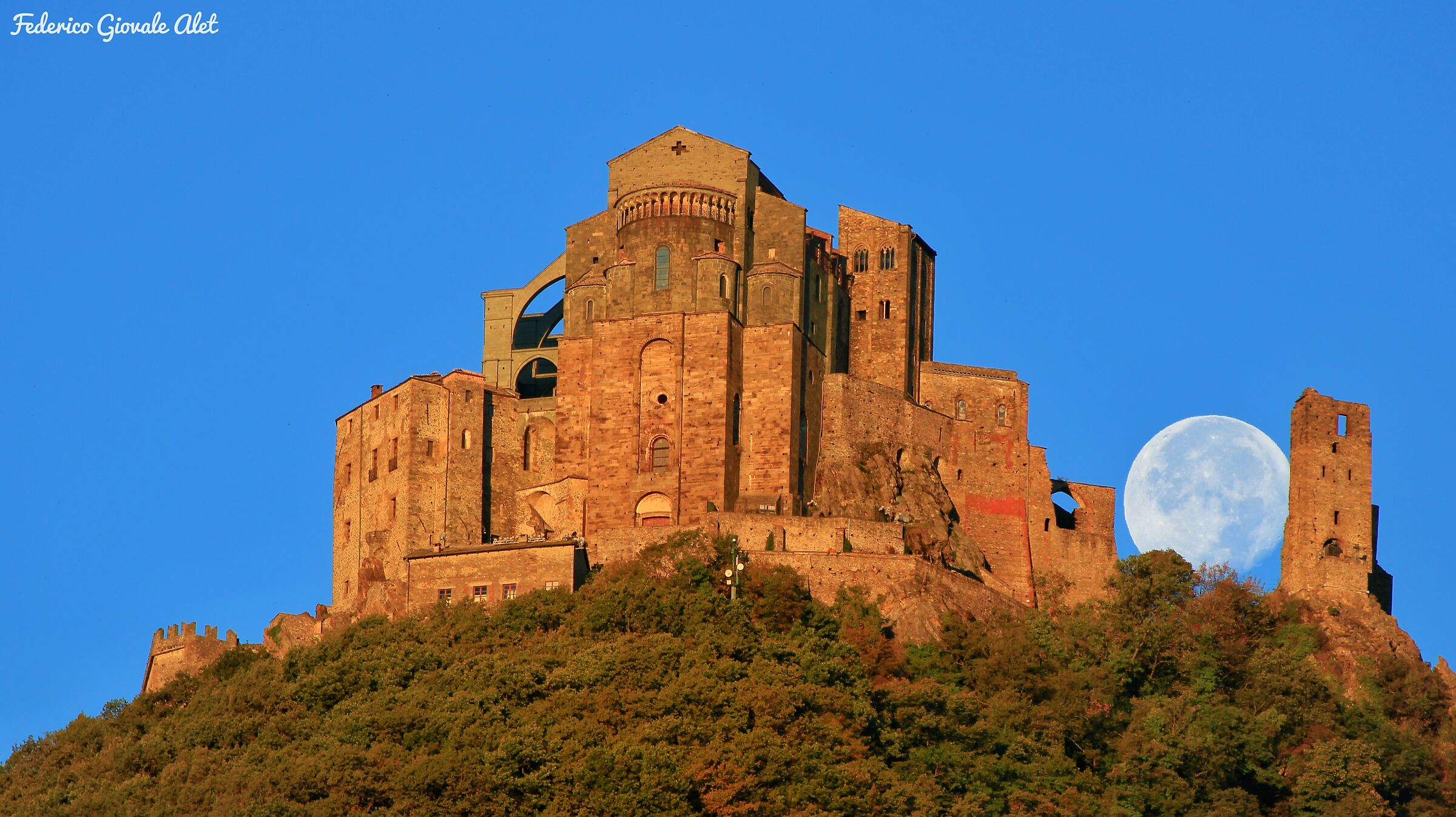 Moon nestled between the Sacred and the Tower of The Beautif...