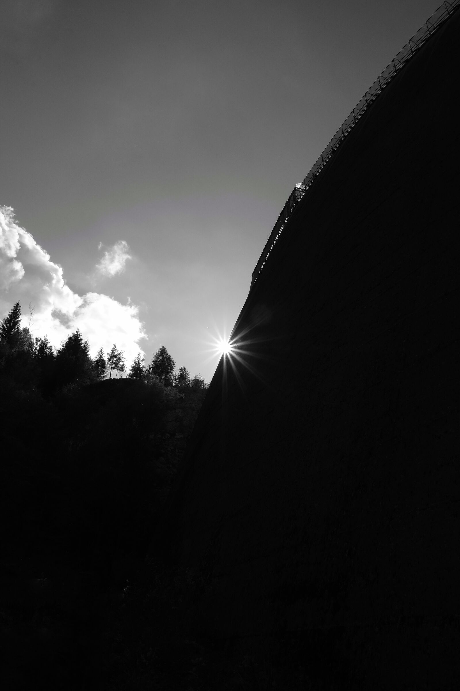 The sun sets behind the dam