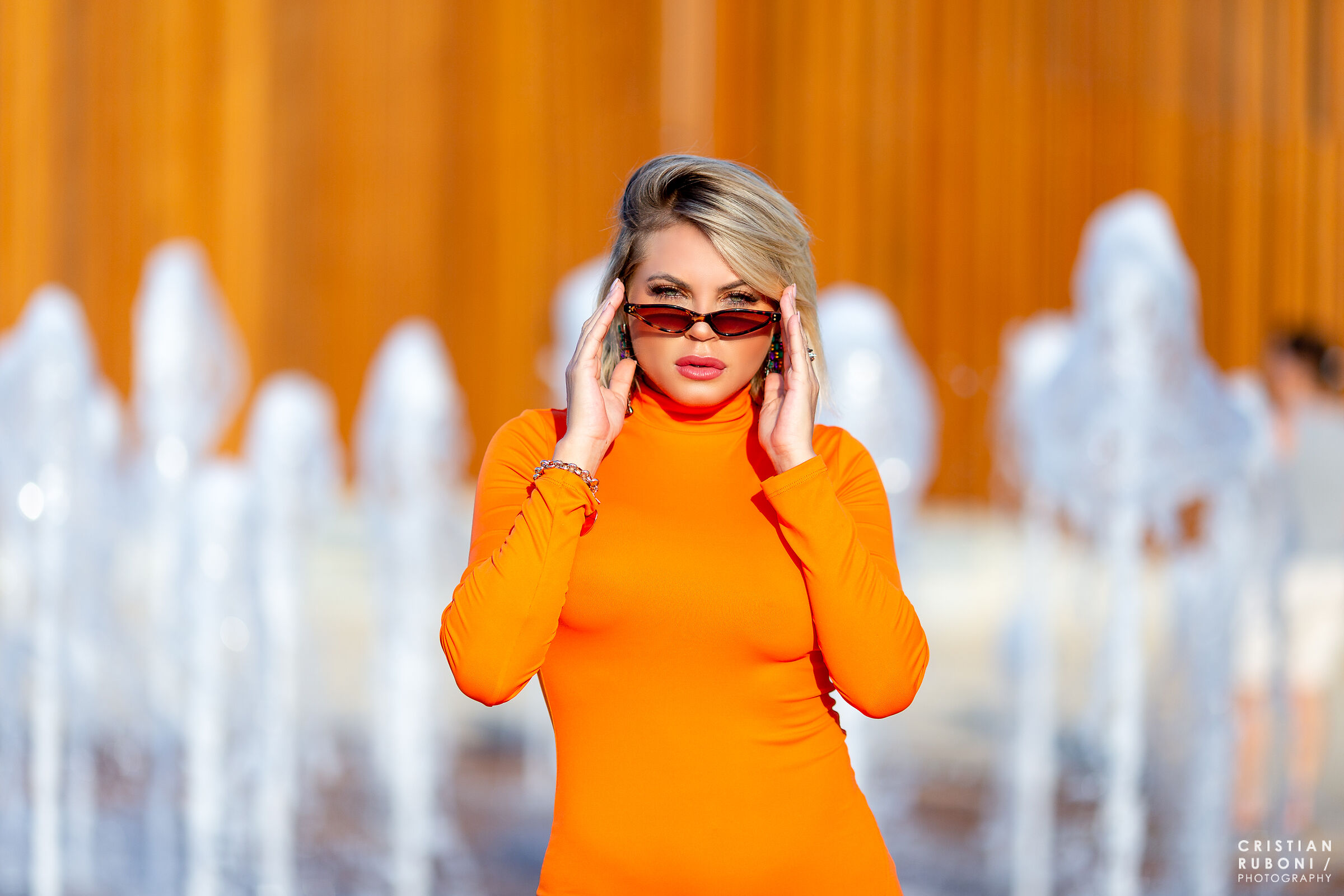 Carol posa in vestito aderente arancione