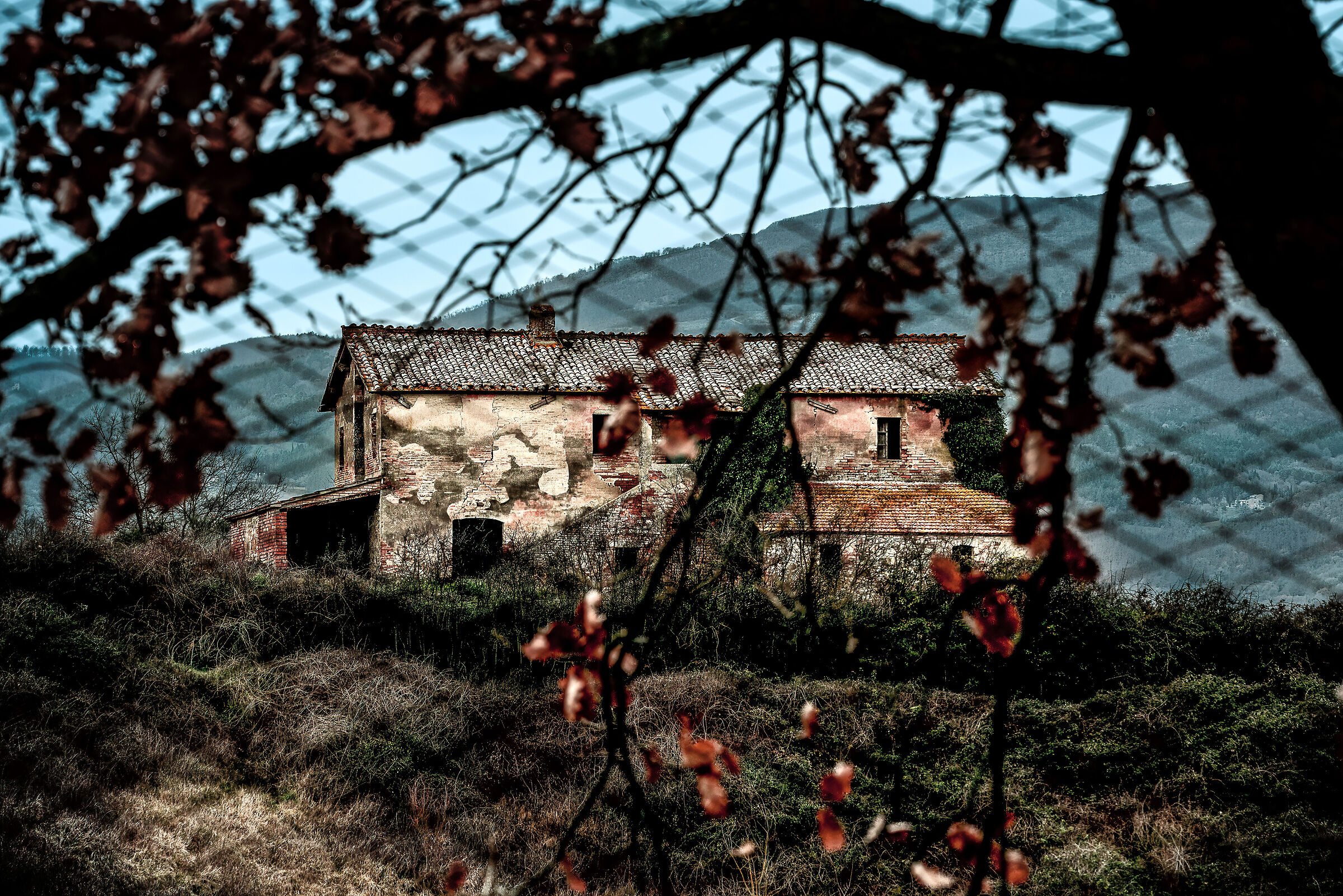 casolare abbandonato in campagna umbra su sfondo toscan