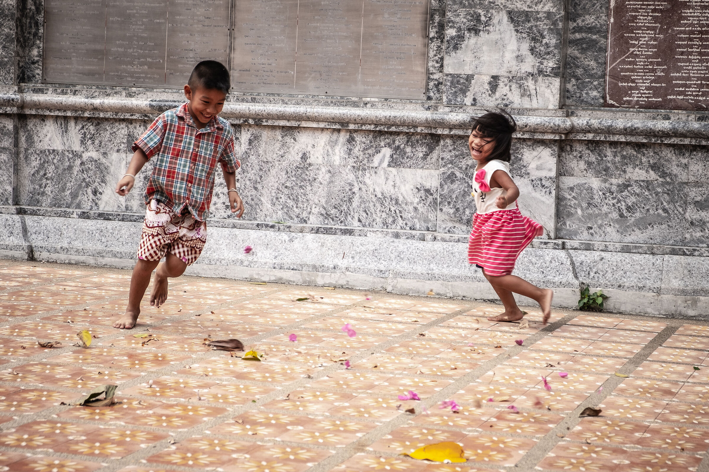 Bambini che rincorrono petali al tempio - Tailandia