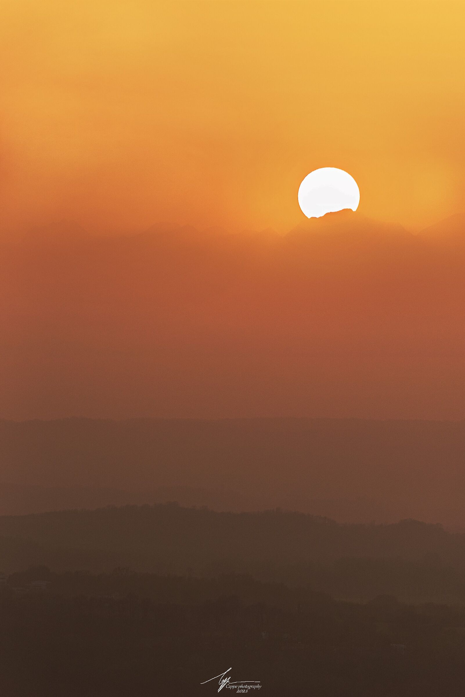 Il sole al tramonto che si nasconde dietro le montagne