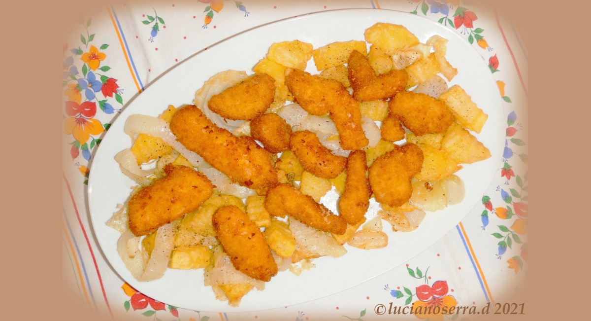 Breaded chicken fillets with fried potatoes and onions
