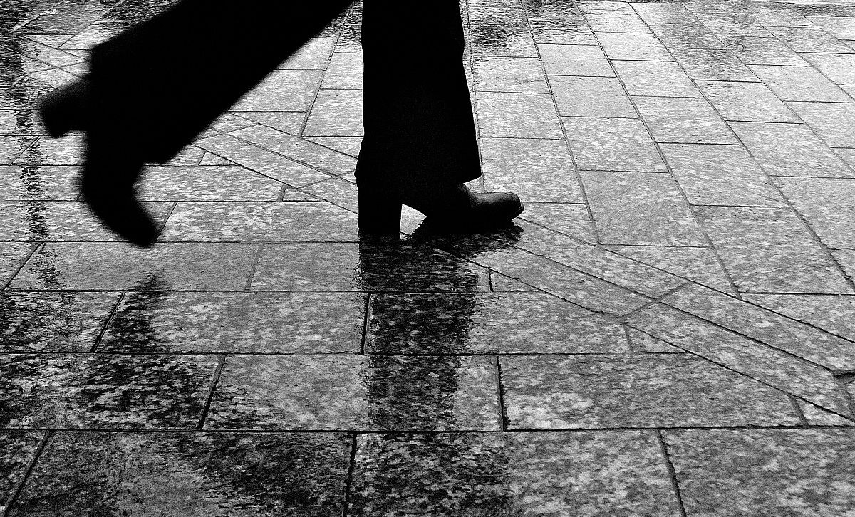 Piedi sul marciapiede bagnato