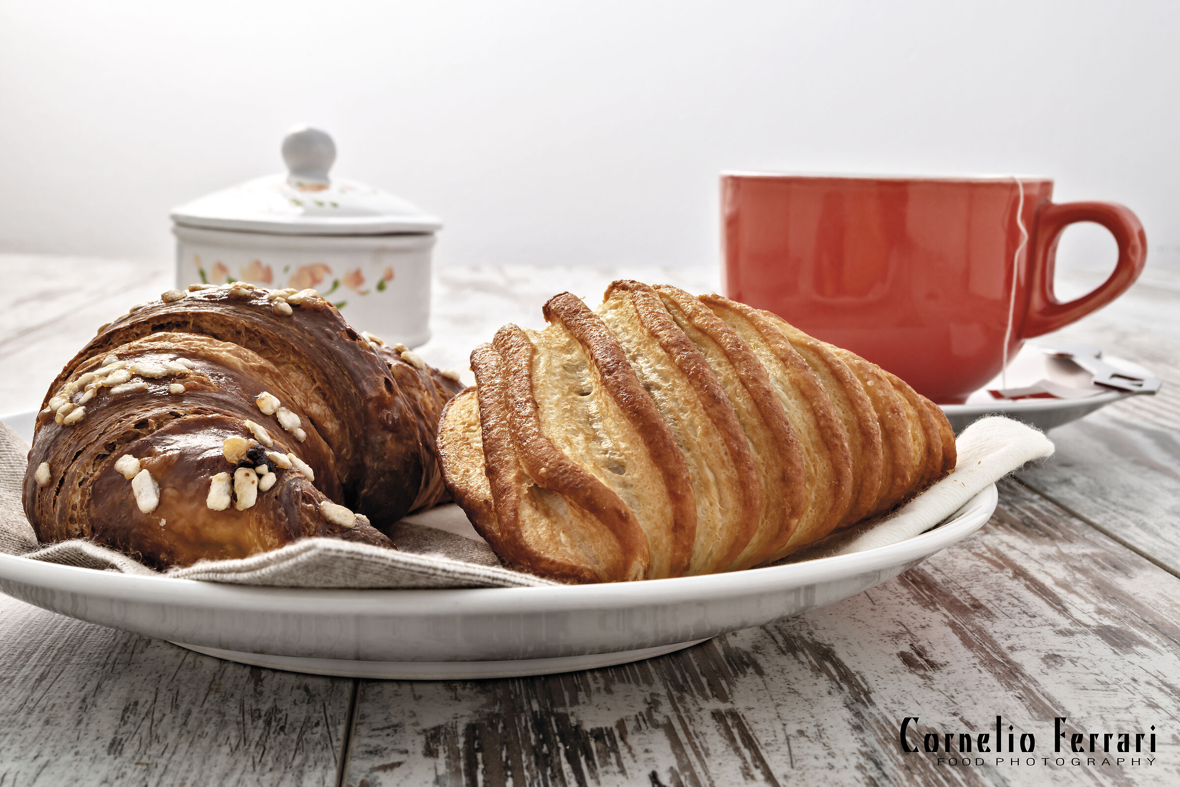 due brioche nel piatto fronte con tazza the