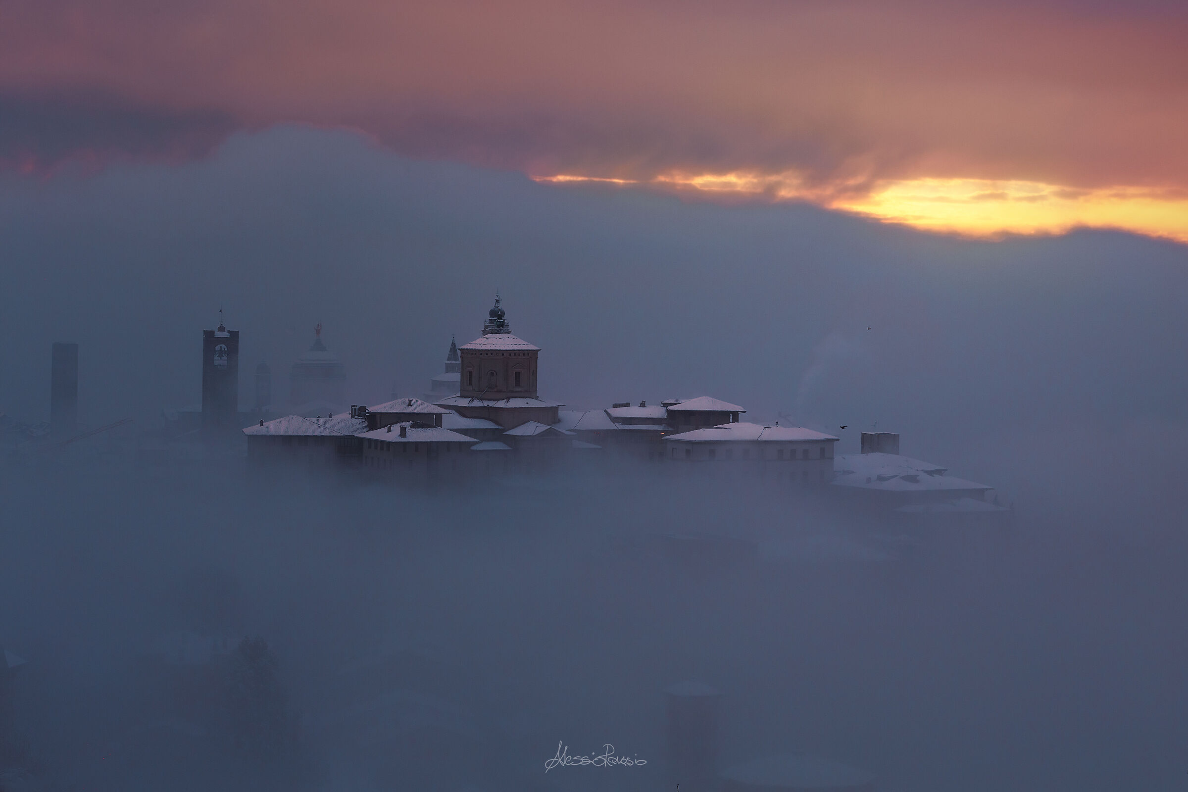 Bergamo Alta si sveglia imbiancata e tra la nebbia