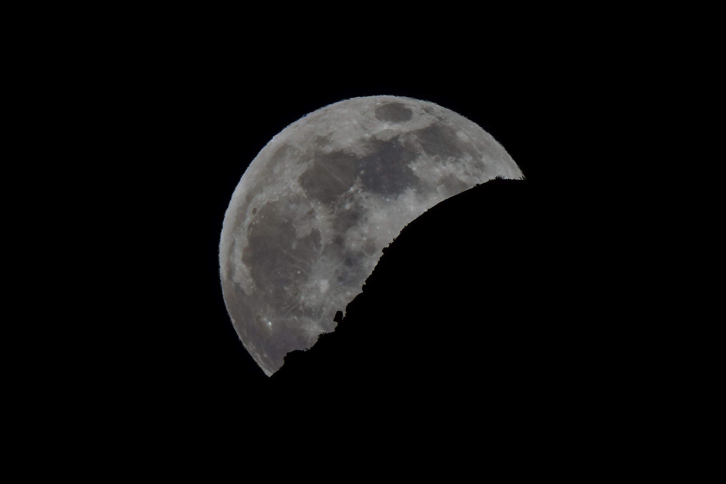 The moon rises from the mountain