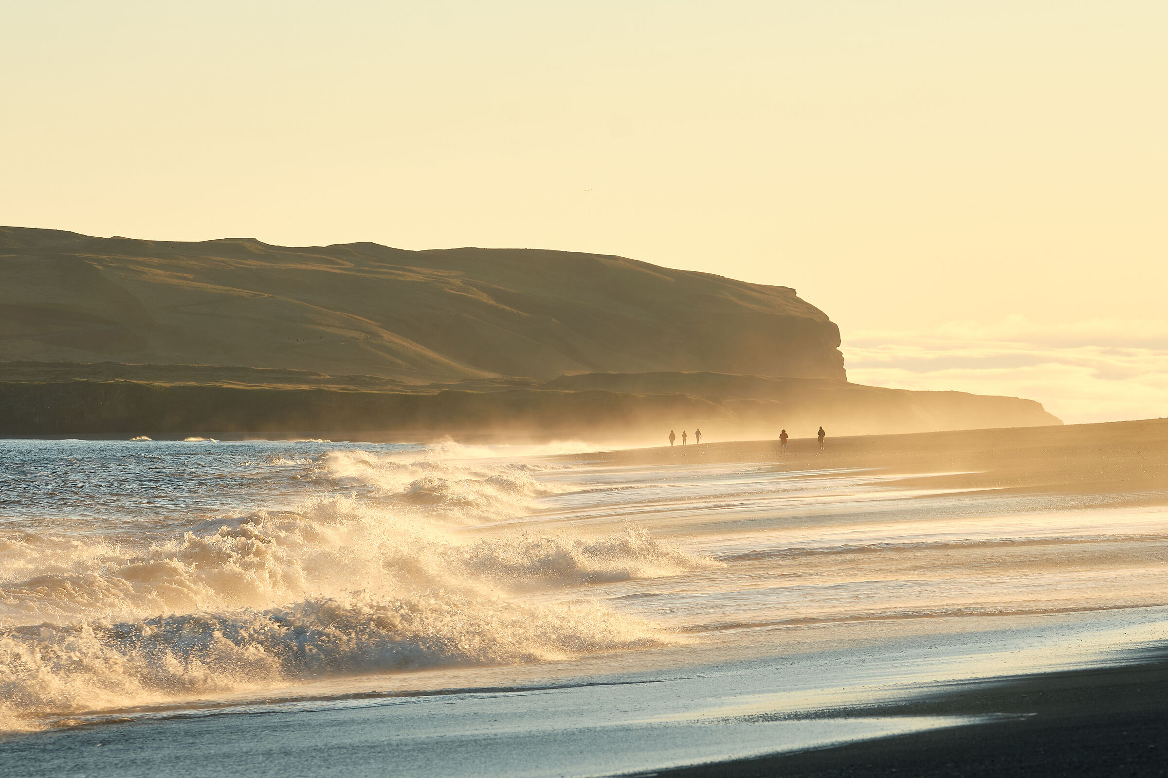 The golden sea breaks on the Black Beach