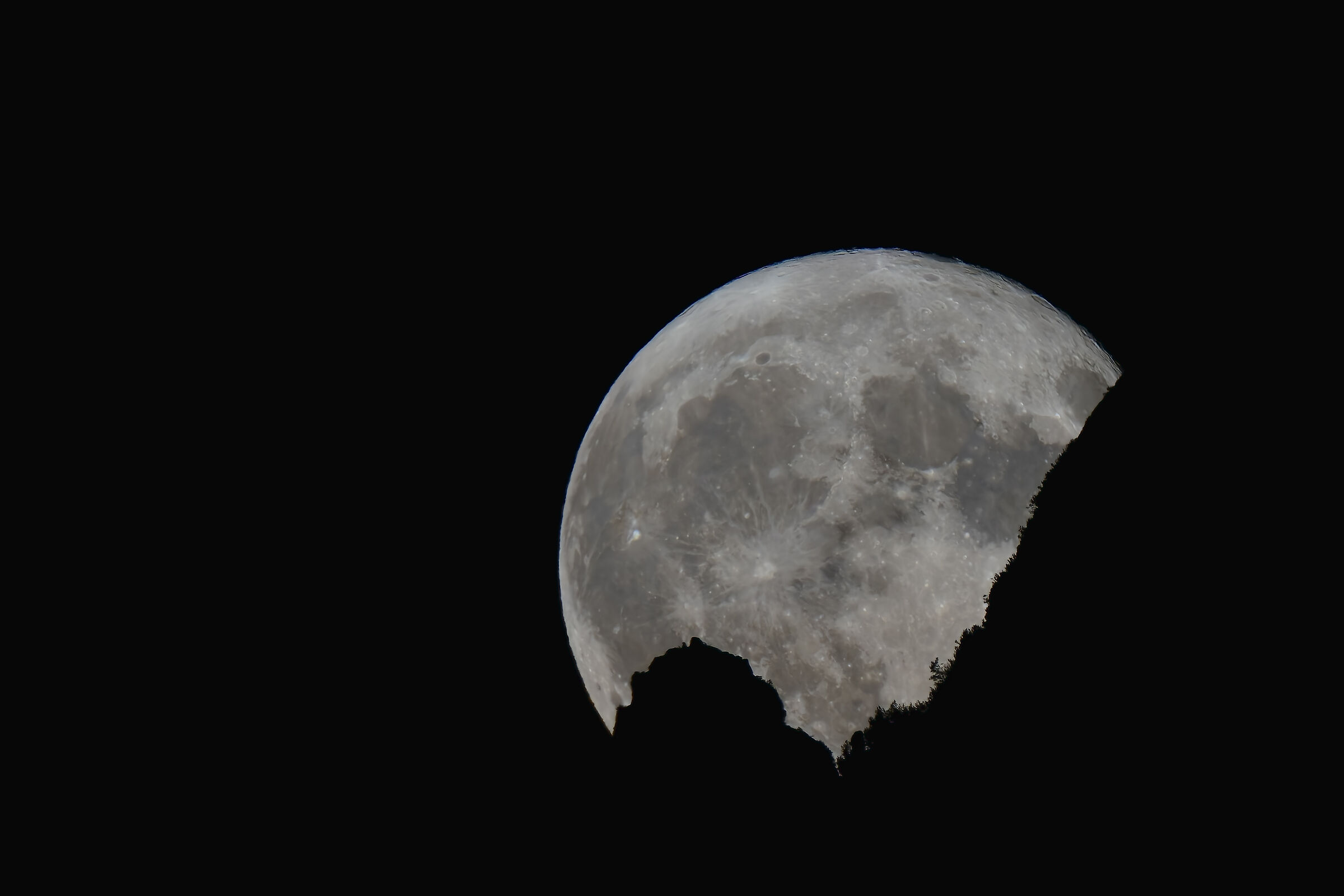 La super luna che si nasconde dietro il monte