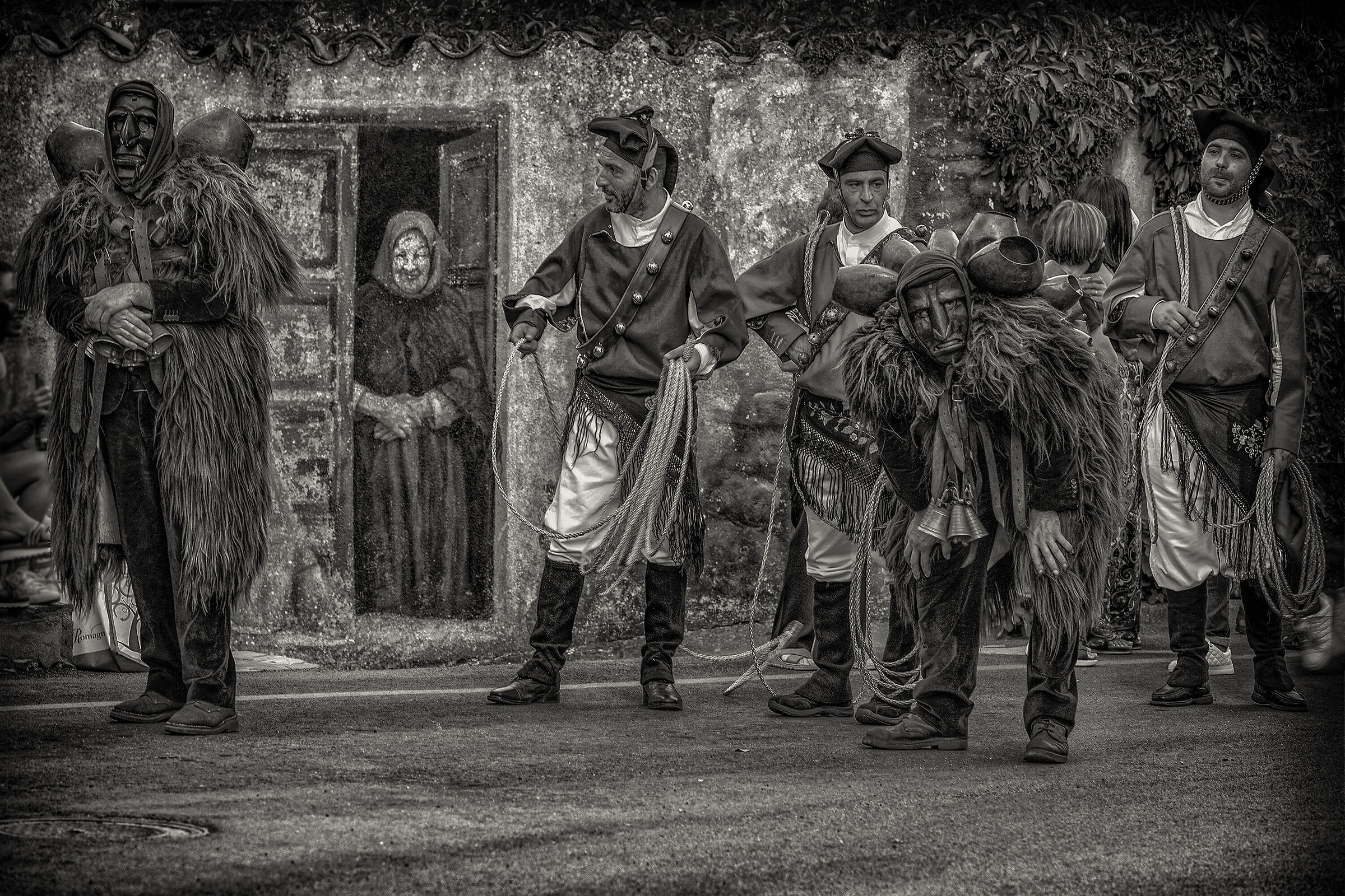 Nonnina che osserva curiosa i Mamuthones e Isshohadores