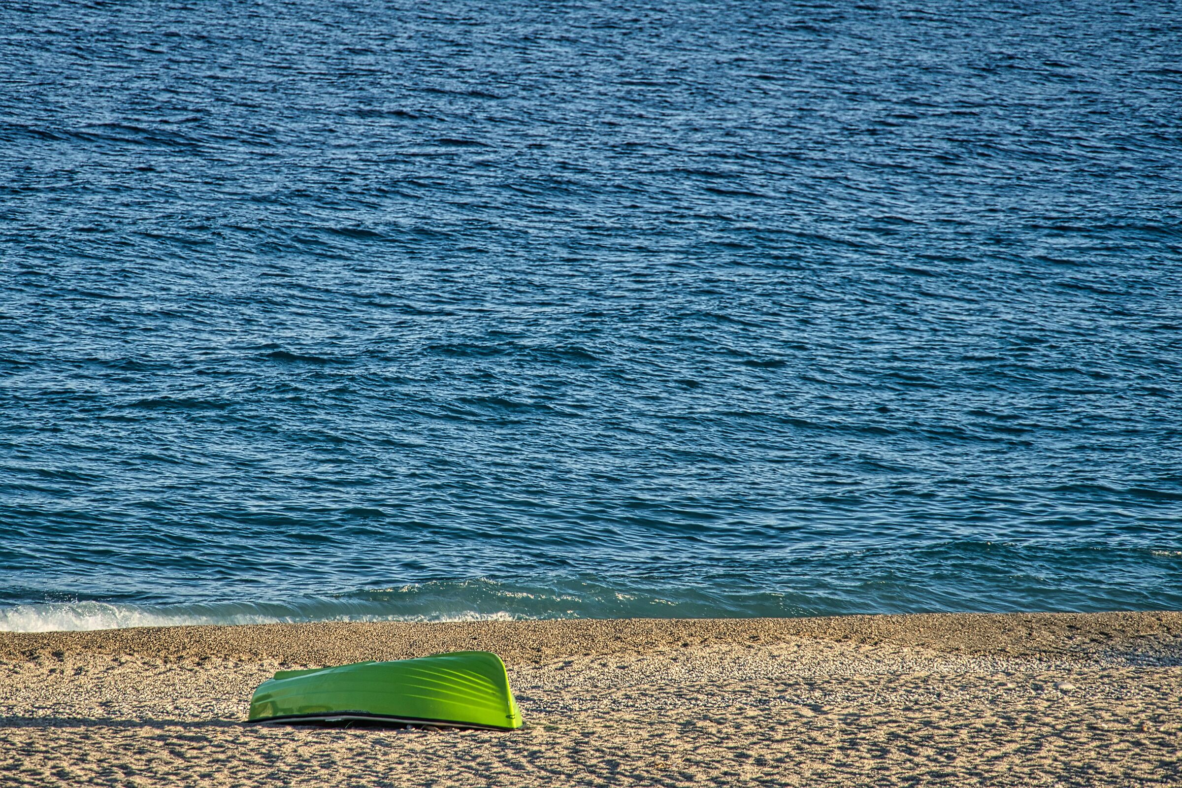 Green boat and blue sea, not to mention the sand...