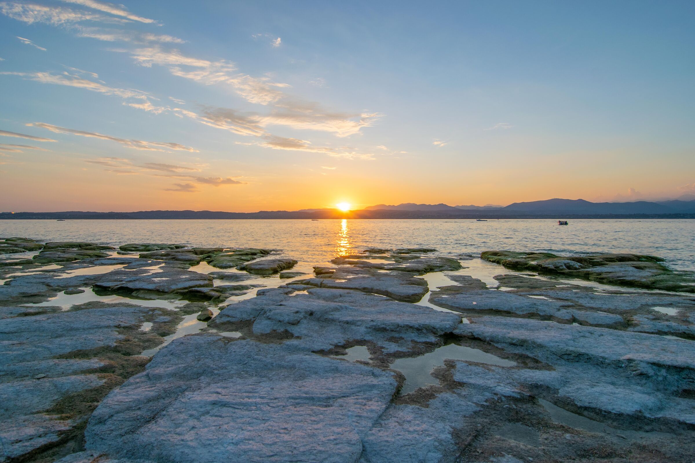 Tramonto su un lago di Garda in siccità
