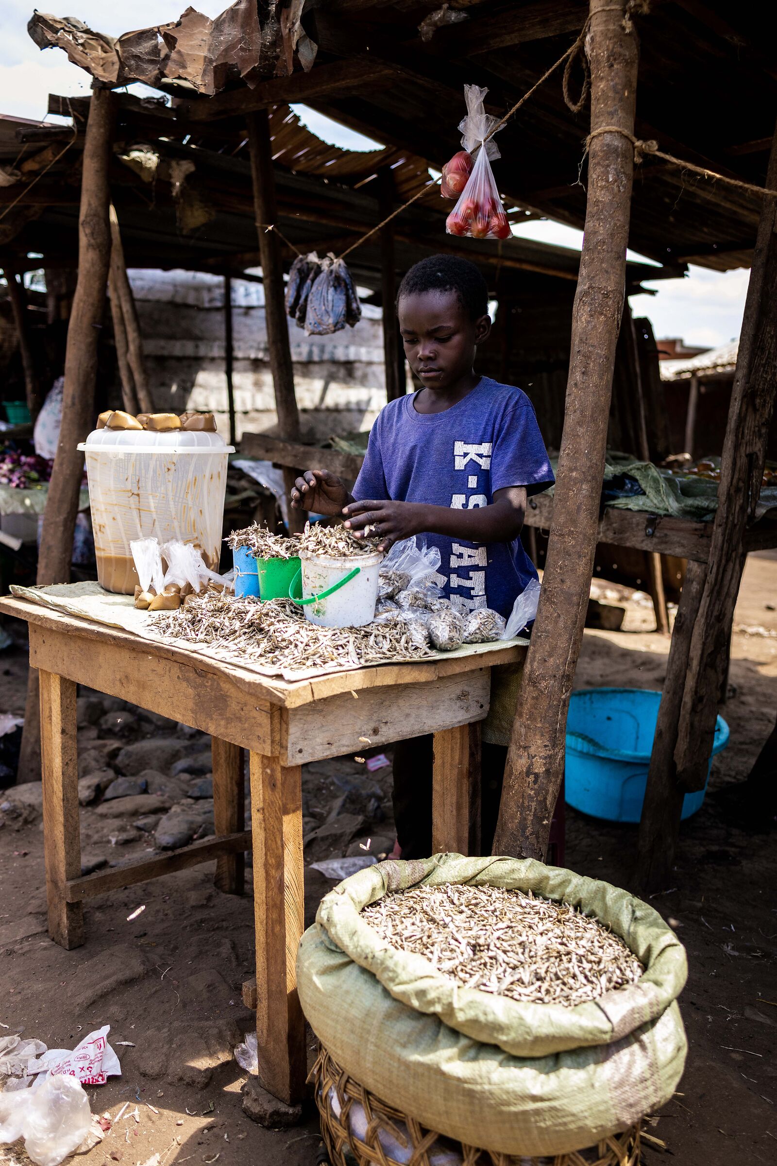 Moroto market - boy selling omega (silver fish)