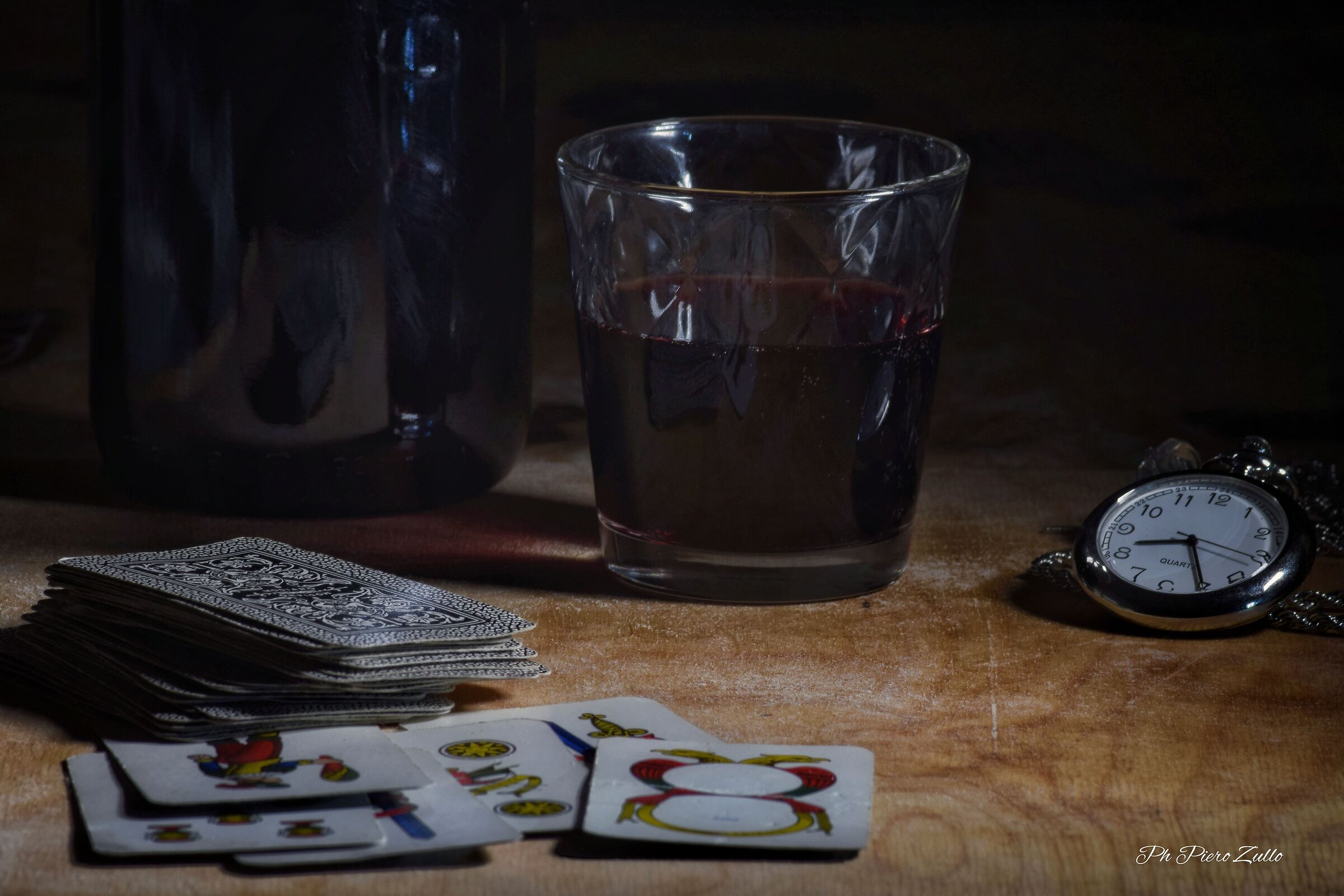 a glass of wine and a game of cards