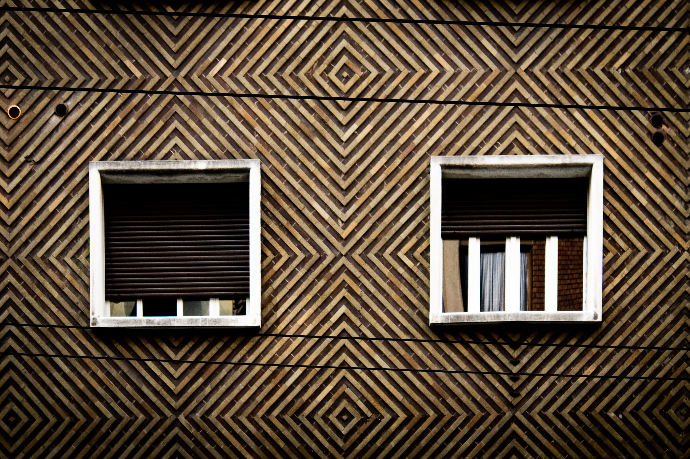 Finestre quadrate su muro a rombi