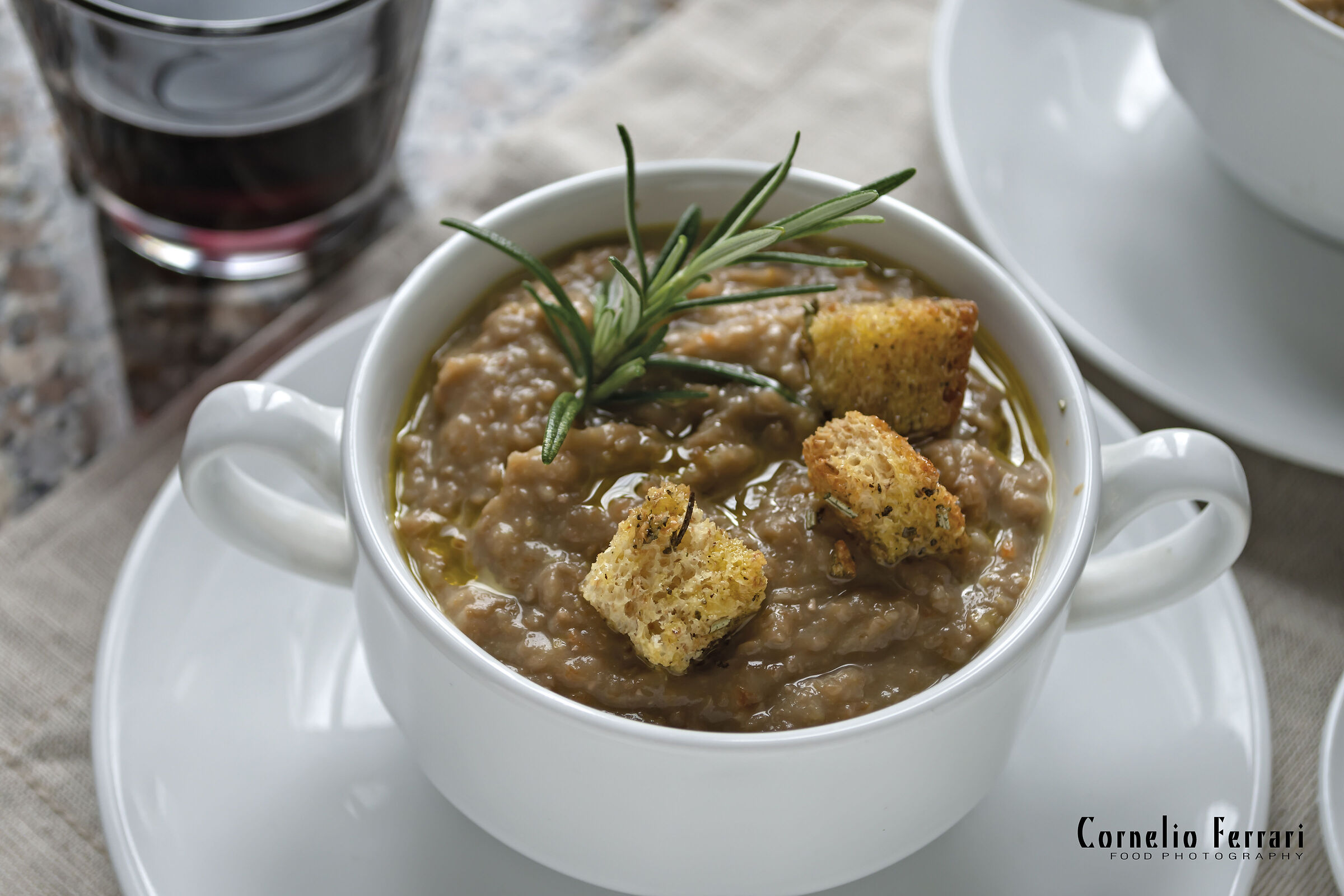 crema di lenticchie in tazza con bicchiere di vino ross