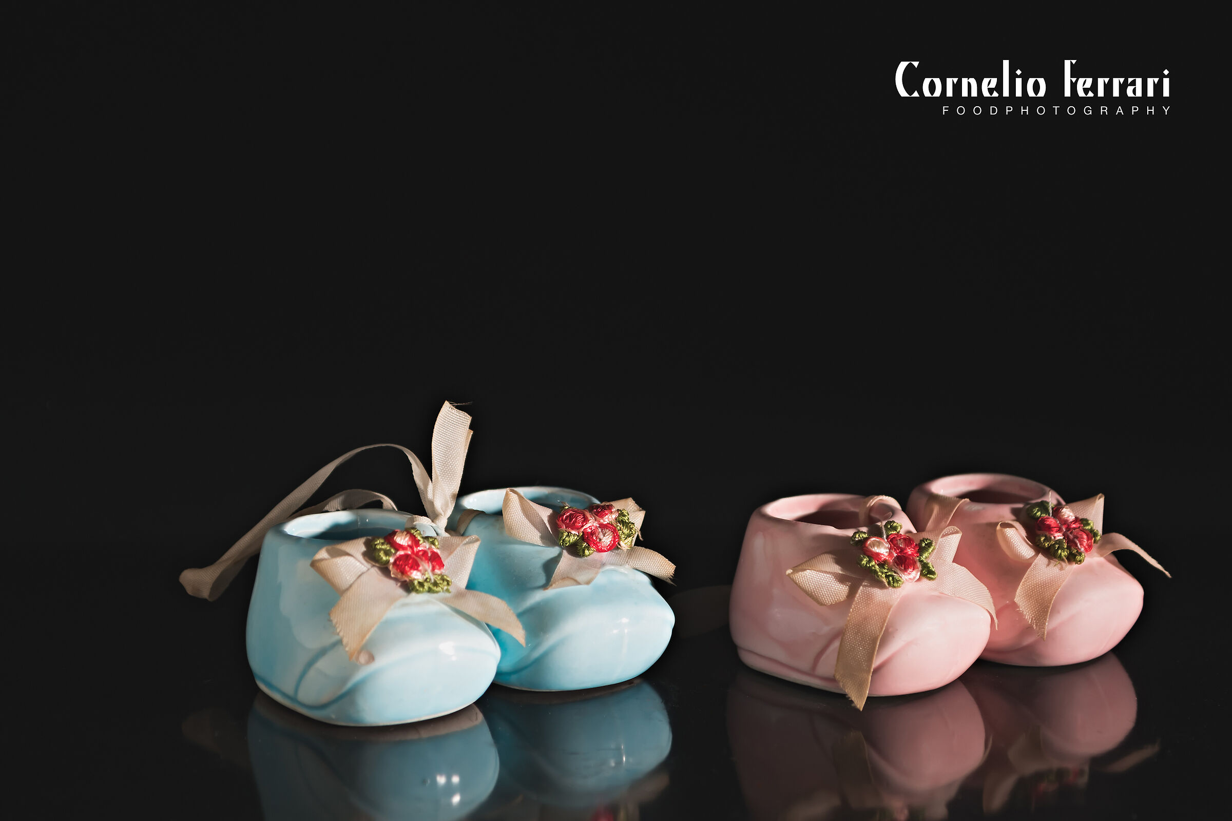 miniatura scarpine neonato azzurre e rosa su fondo nero