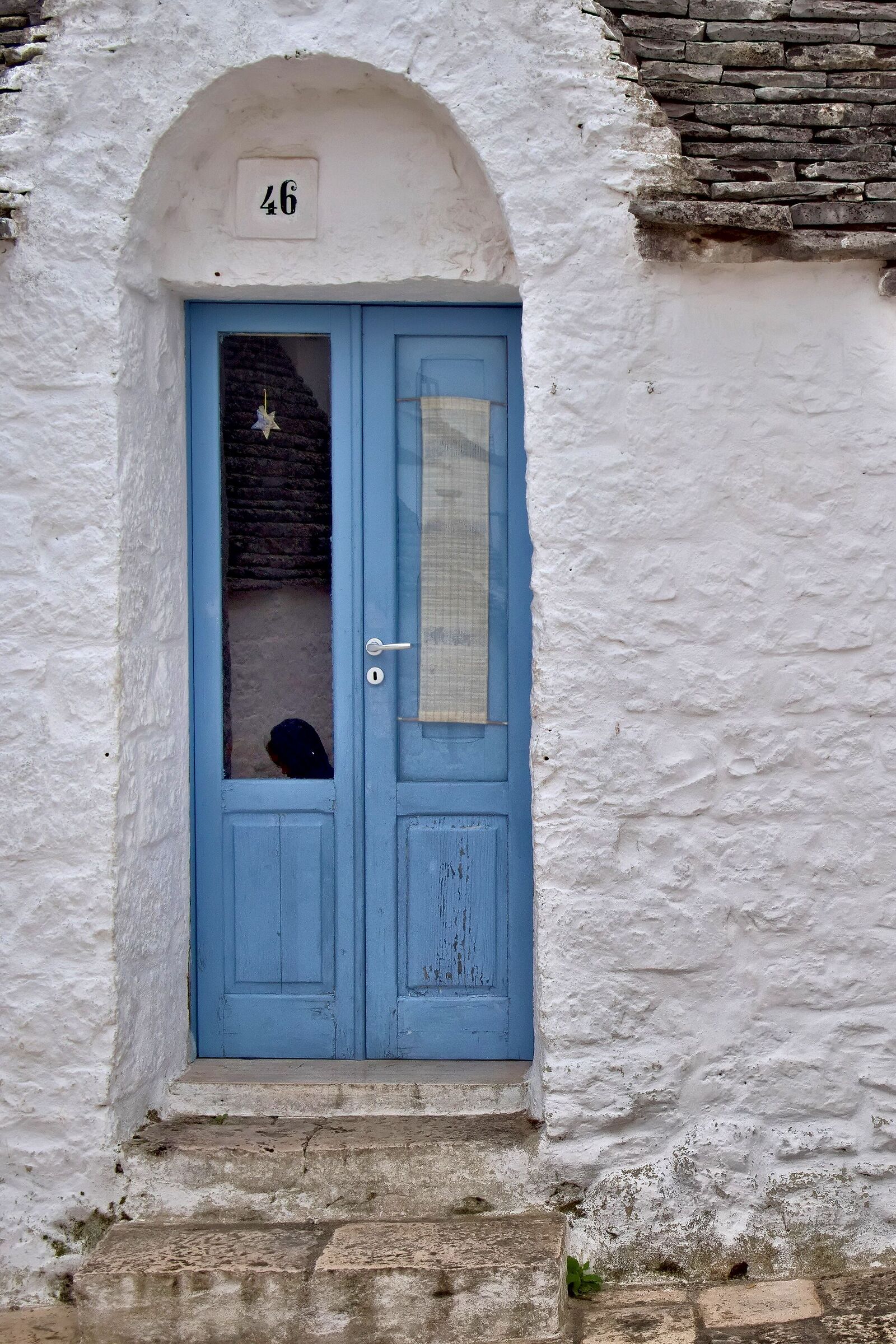 Face reflected on the door of the trullo