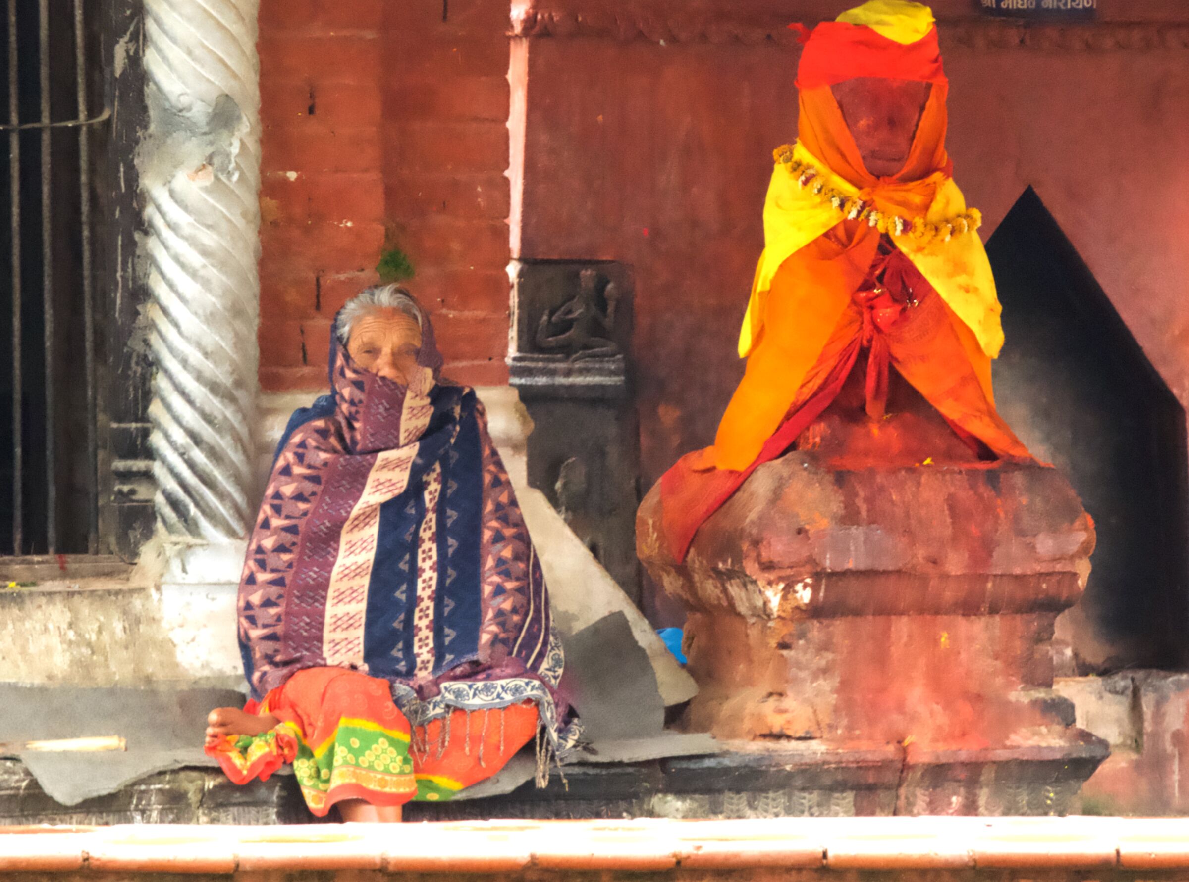 Old woman and statue of Hanuman
