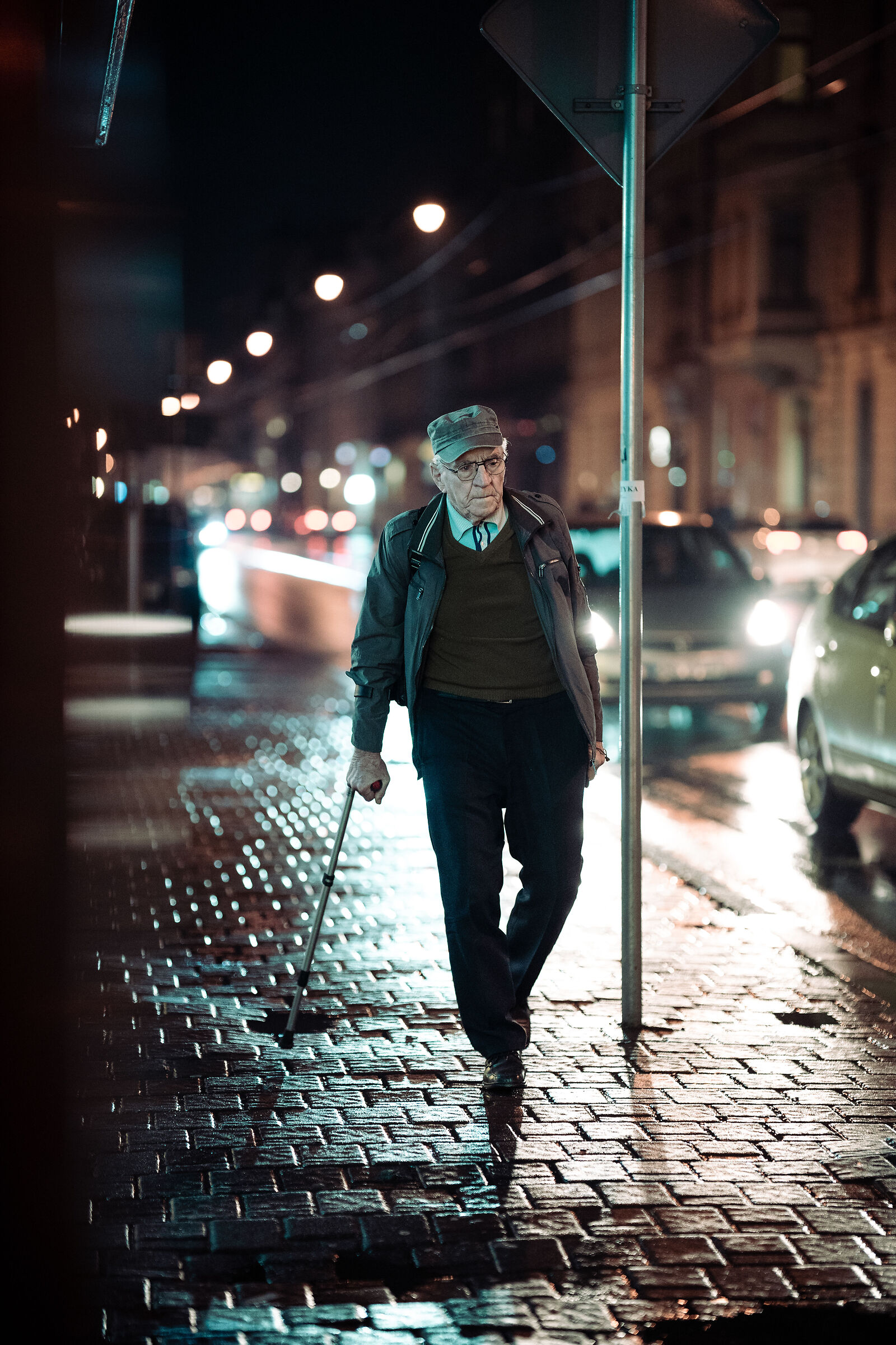 An elderly man walking at night