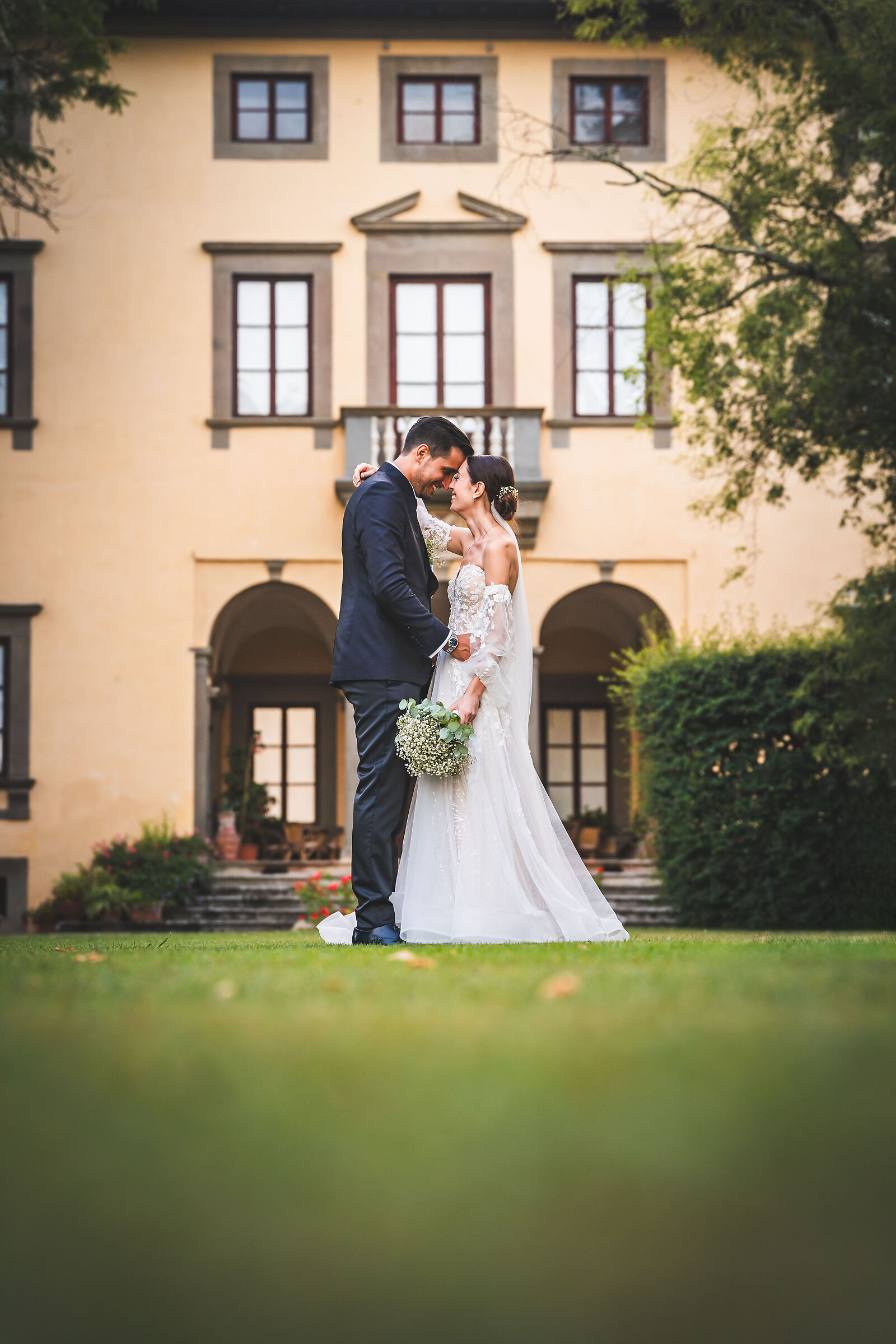 The bride and groom with the Villa behind