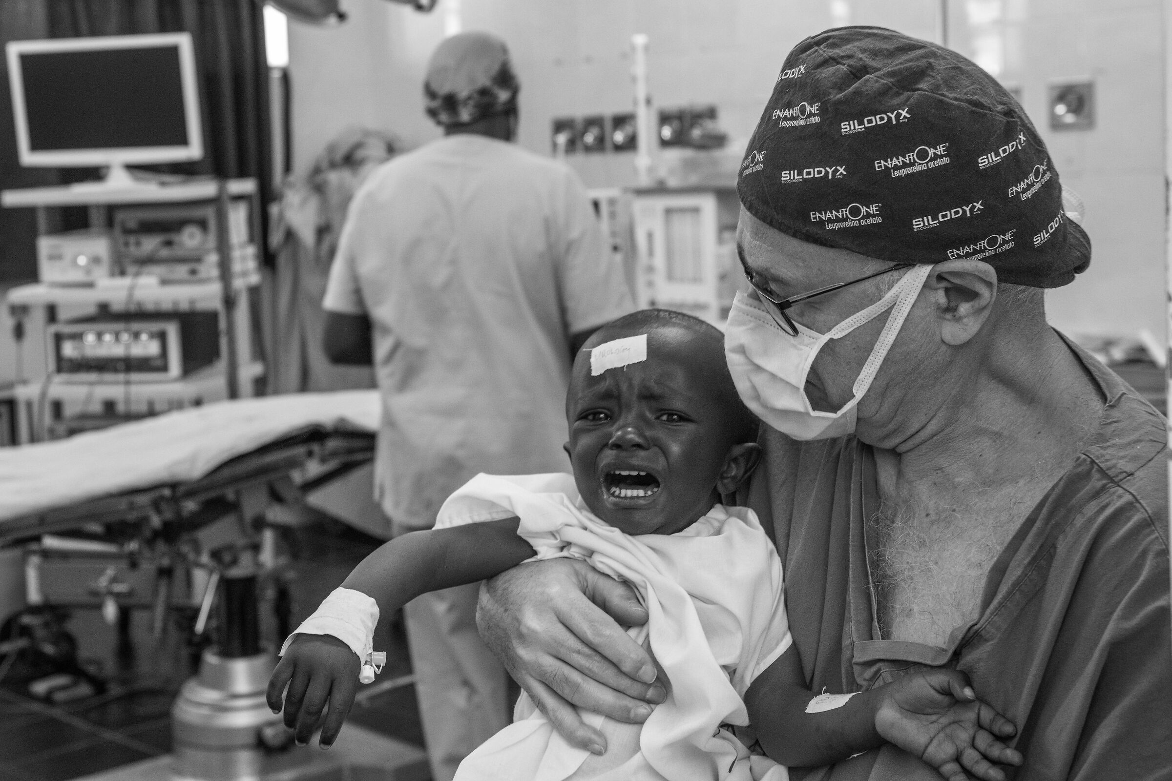 Prof Bruno Frea, holding a baby in his arms.