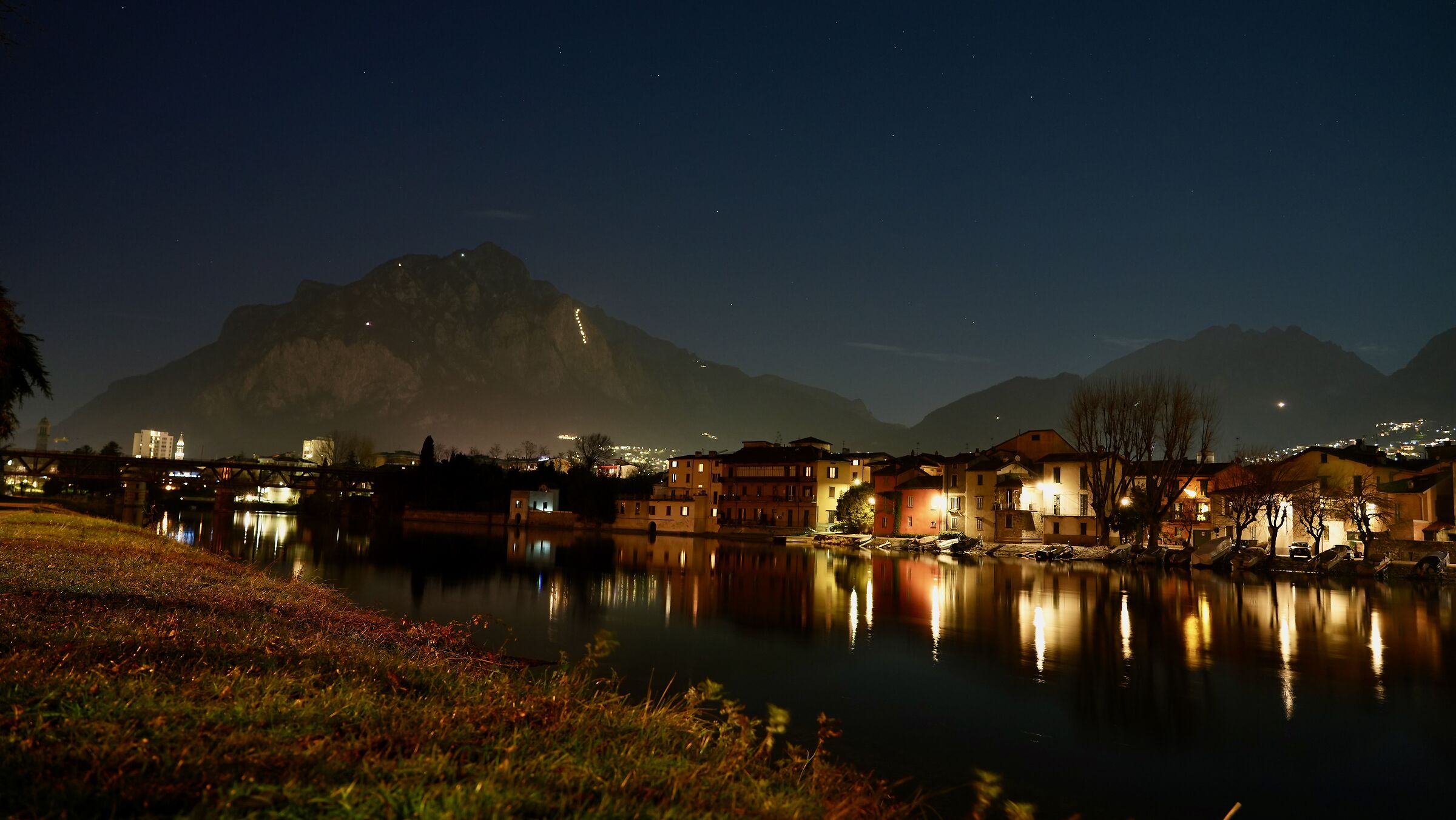 Pescarenico, sullo sfondo fiaccolata sulla montagna