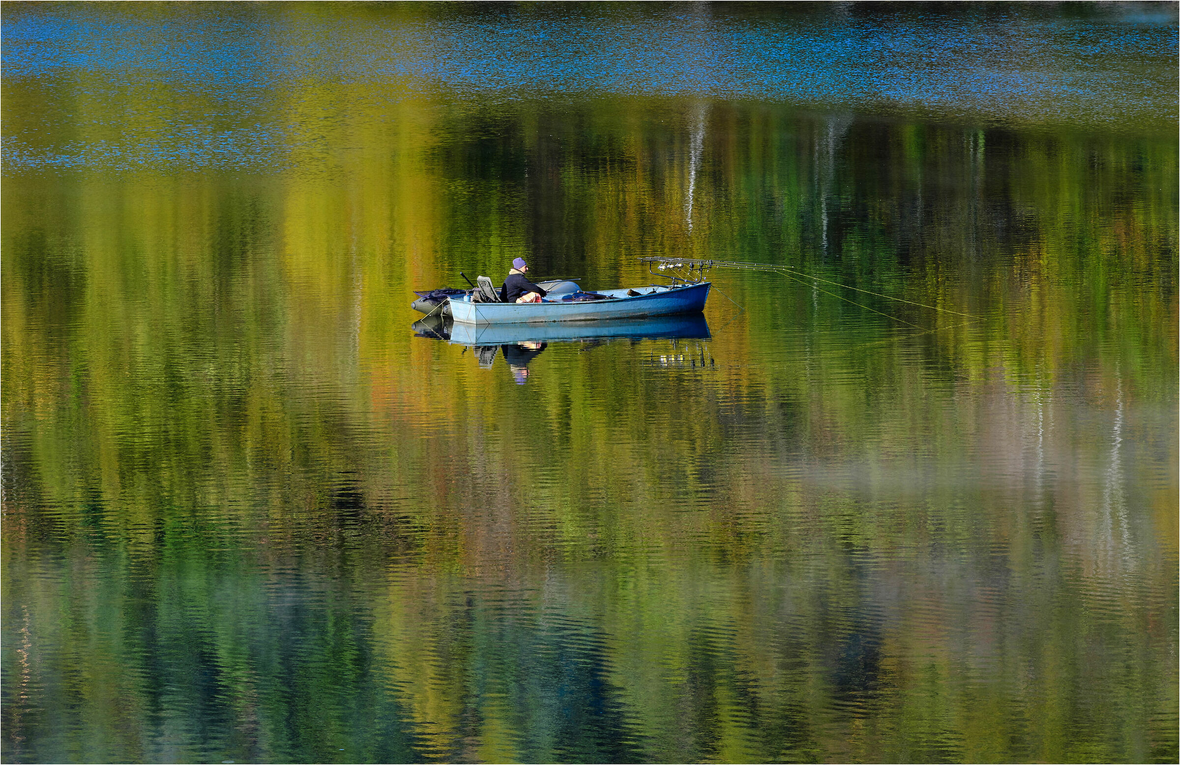 The fisherman at the lake in autumn.