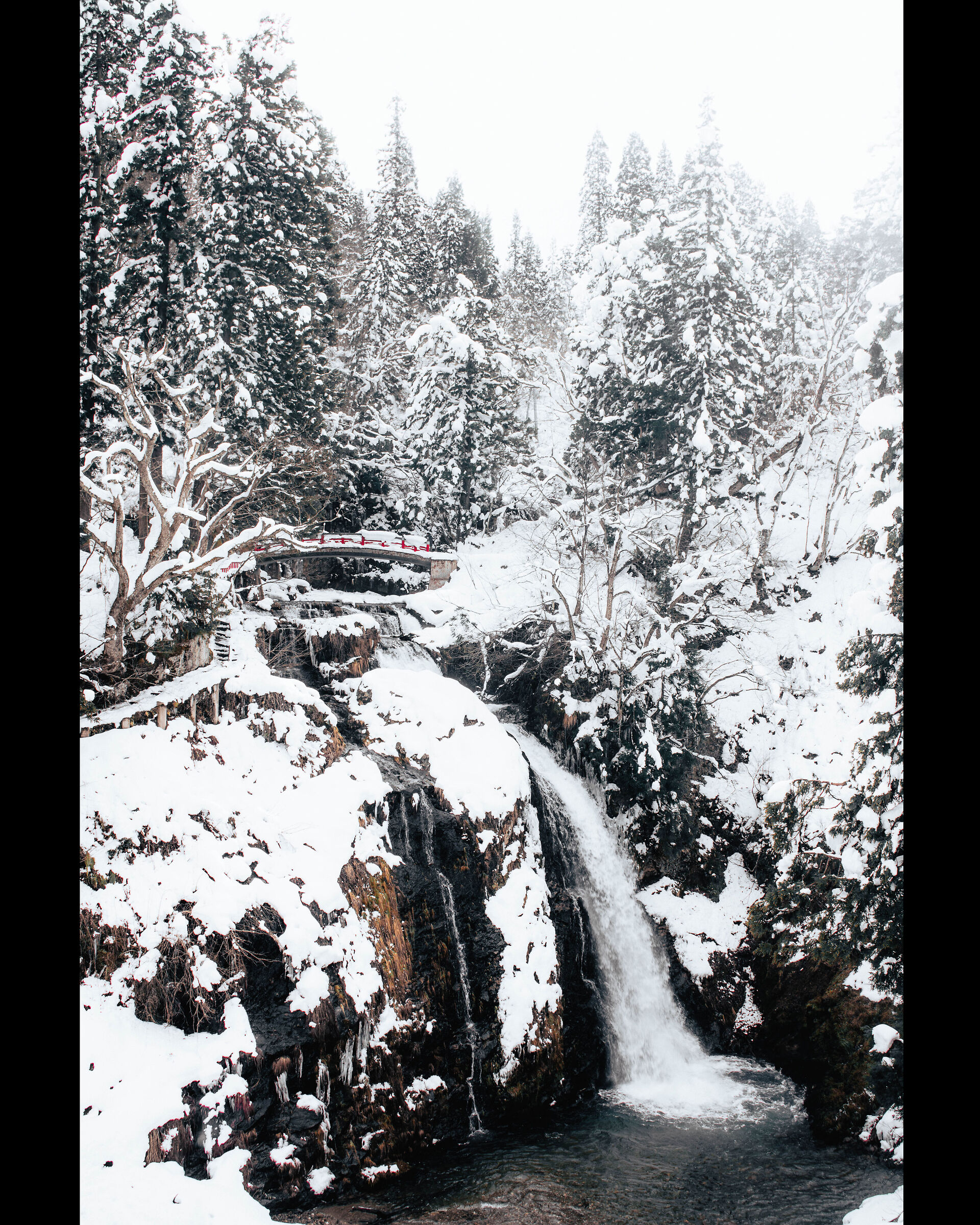 Cascata e ponte rosso alla fine di Ginza Onsen