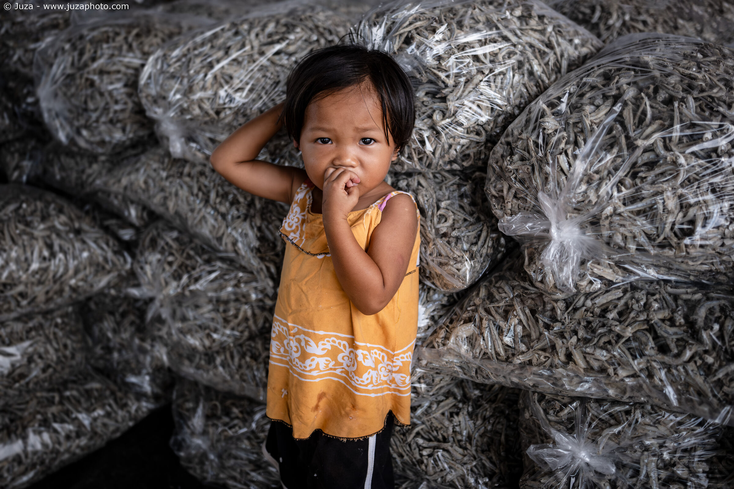Baby girl among dried fish