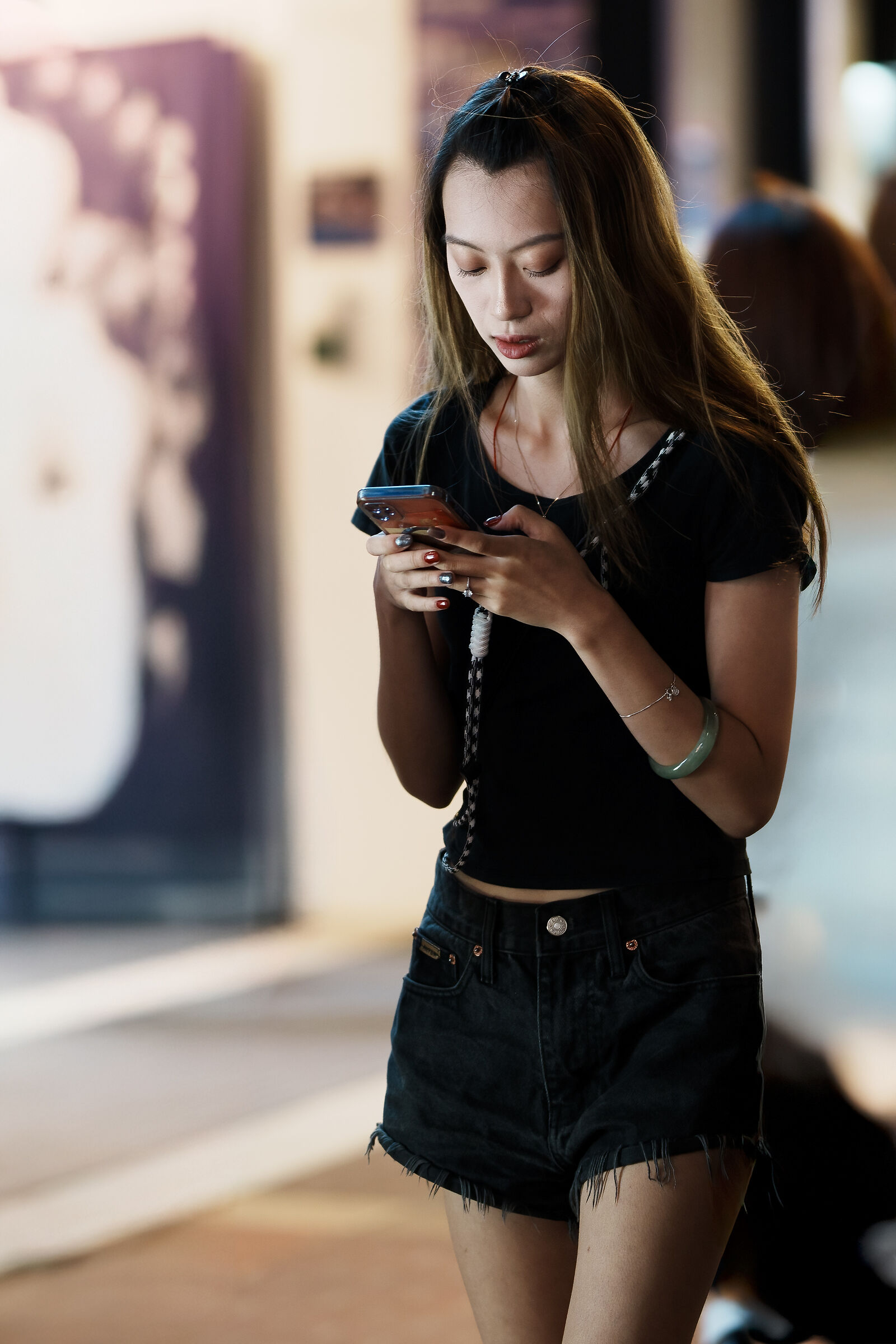 Asian Girl texting in the street