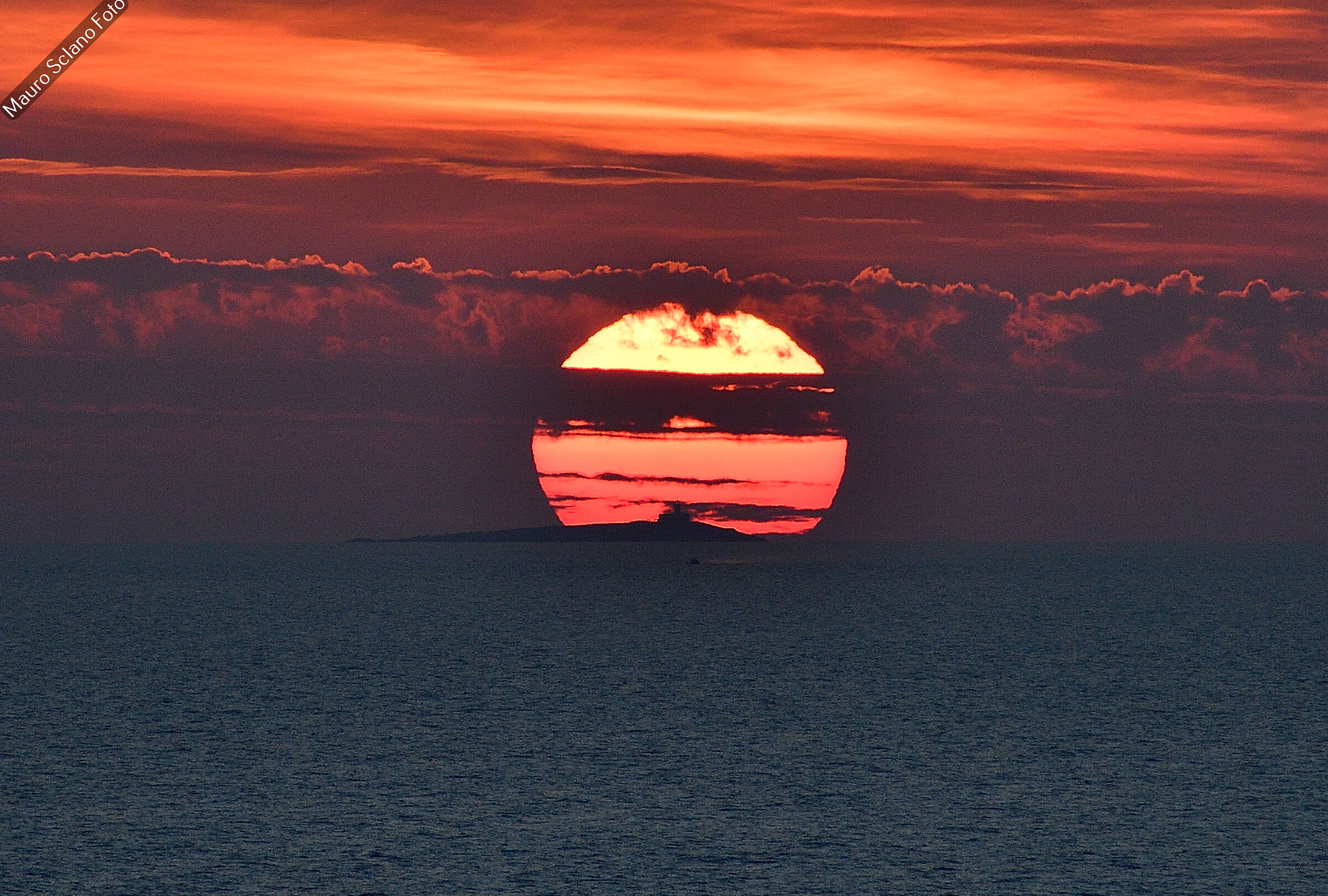 The sun sets over the lighthouse