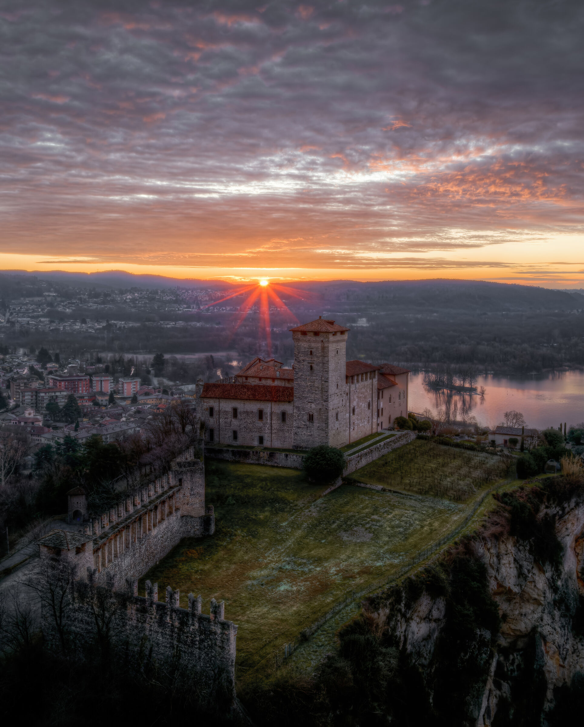 Il sole fa capolino dietro la Rocca di Angera