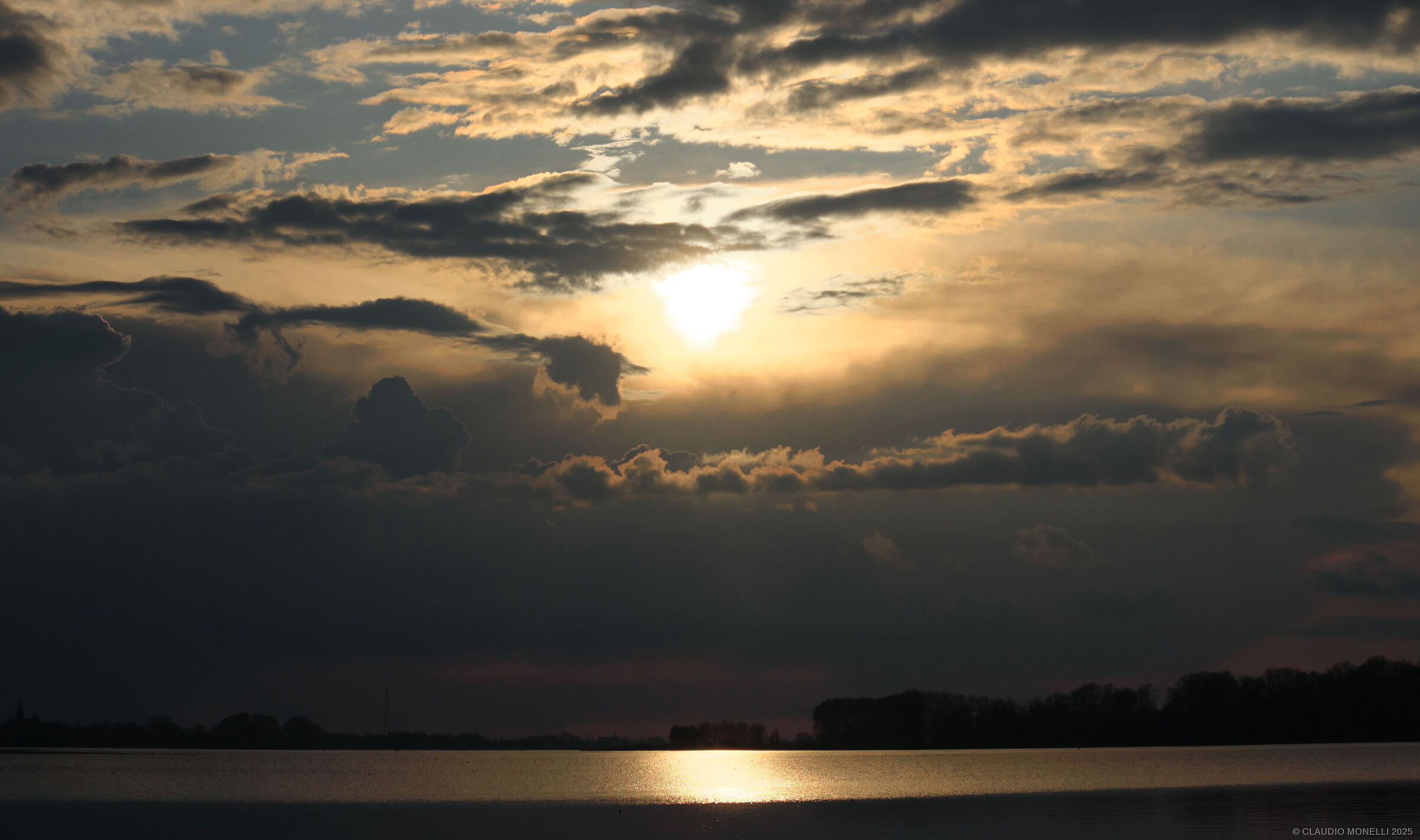 Nuvole e sole al tramonto sul lago di Sopra
