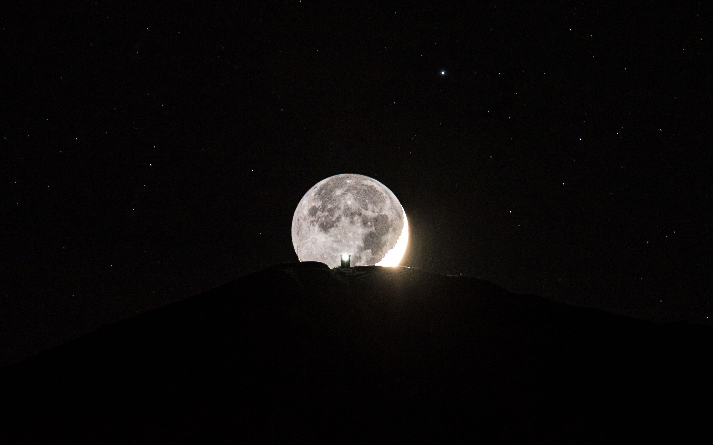 Crescent moon passes over the bell tower of Monte Alto