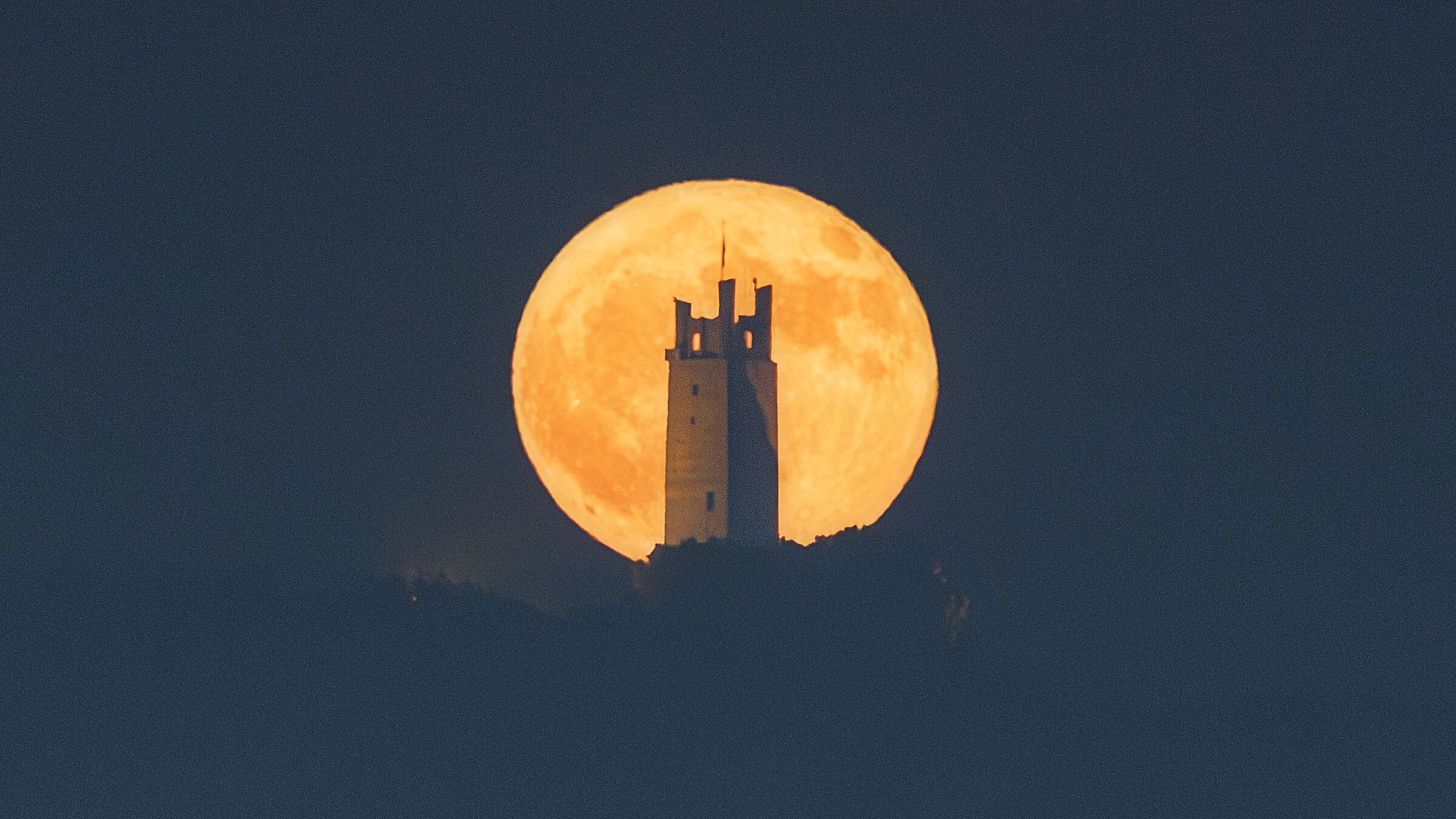 The moon behind the Tower of San Miniato