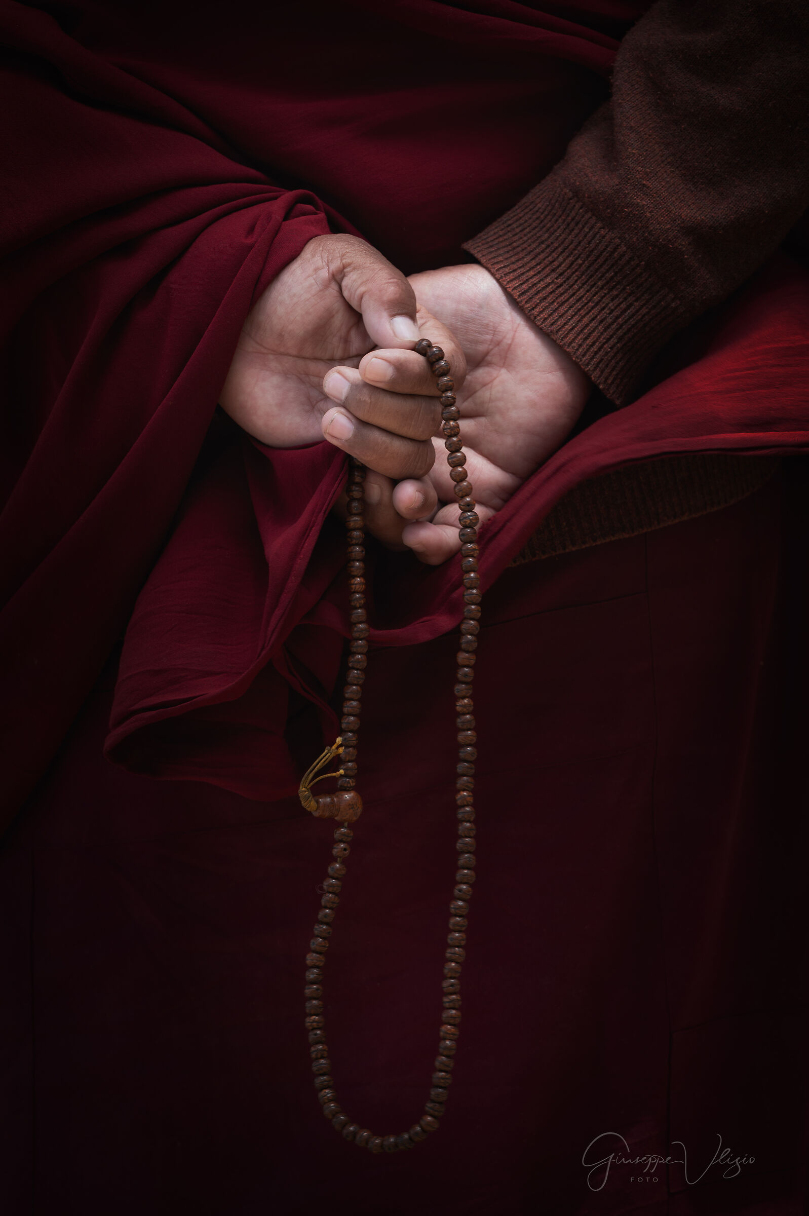 Una mano, un mala, il silenzio della preghiera.