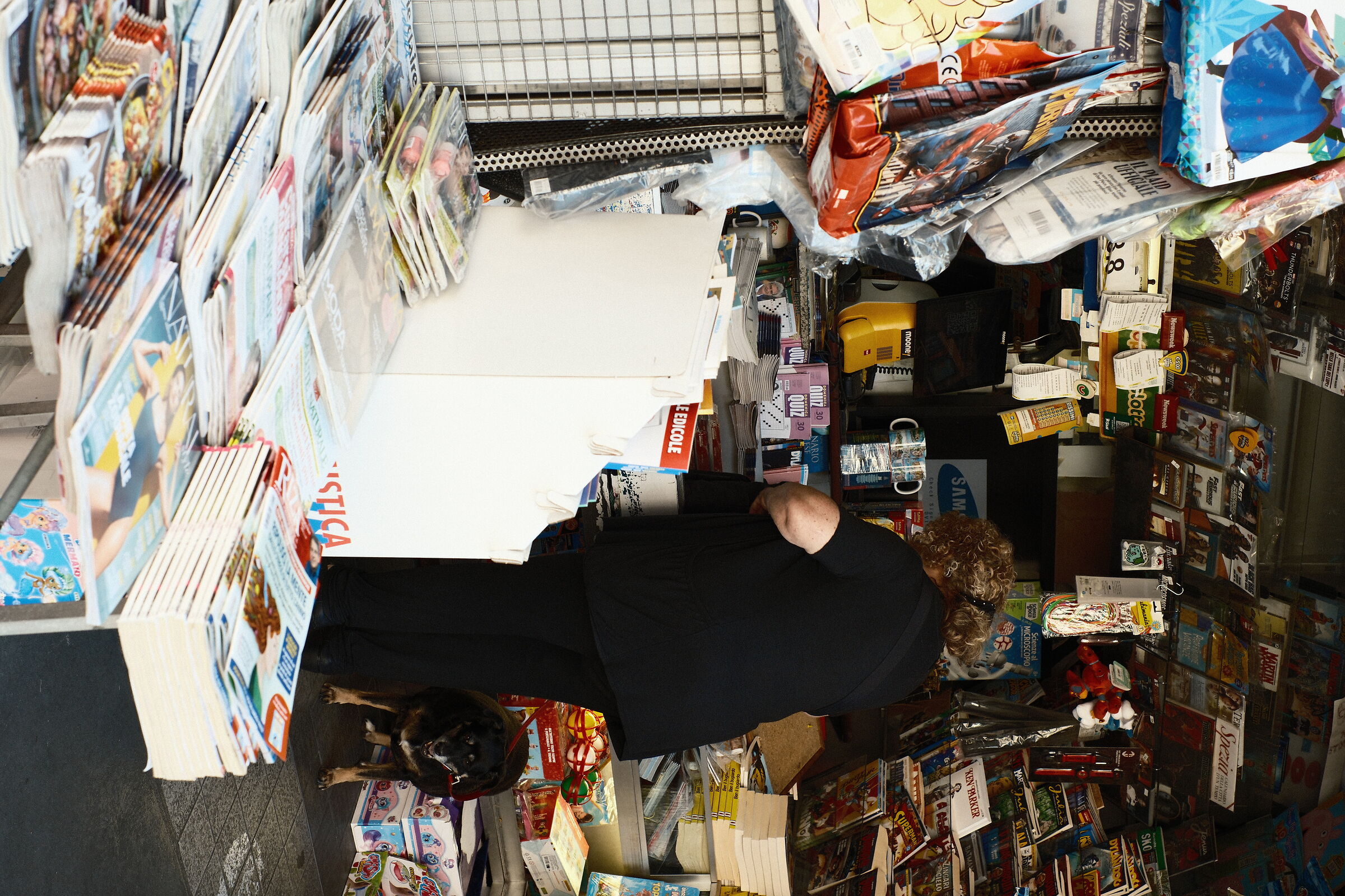 Lady with dog at the newsstand