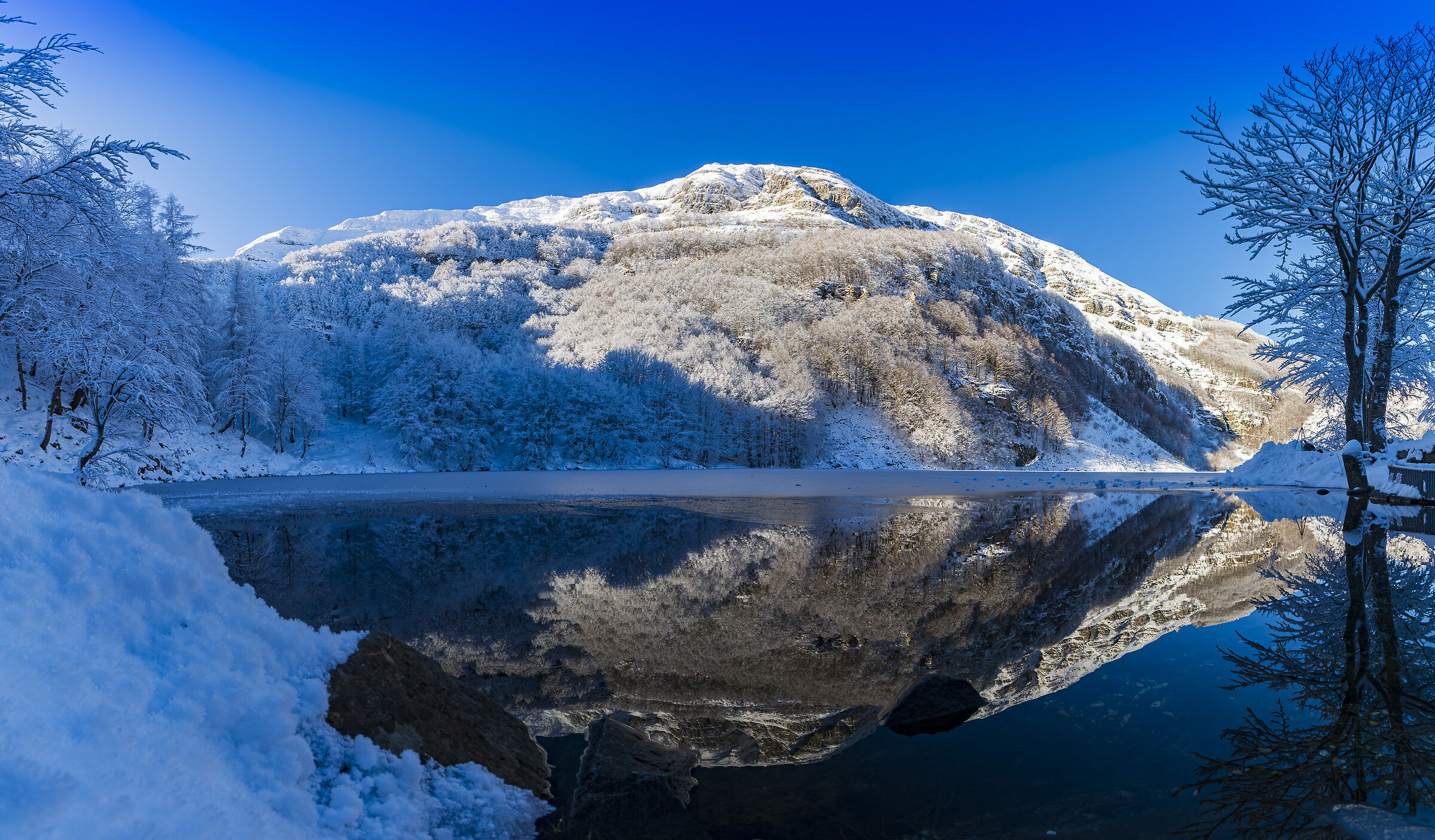 Mount Giovo mirrored on the frozen lake