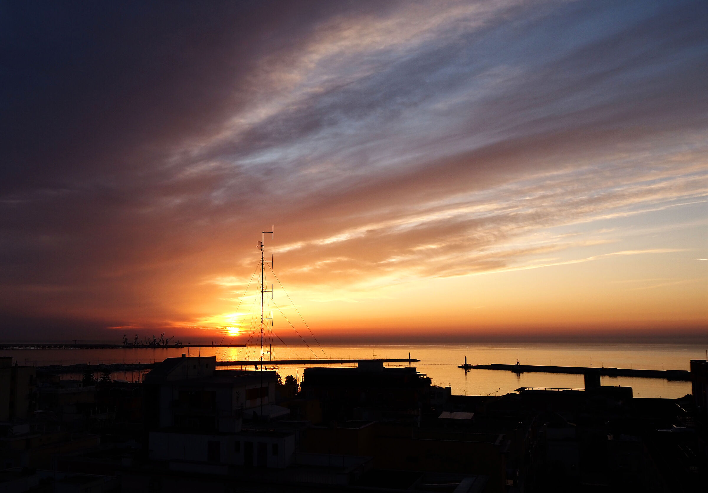 Sunrise and antenna.. sky and sea.. port and roofs.