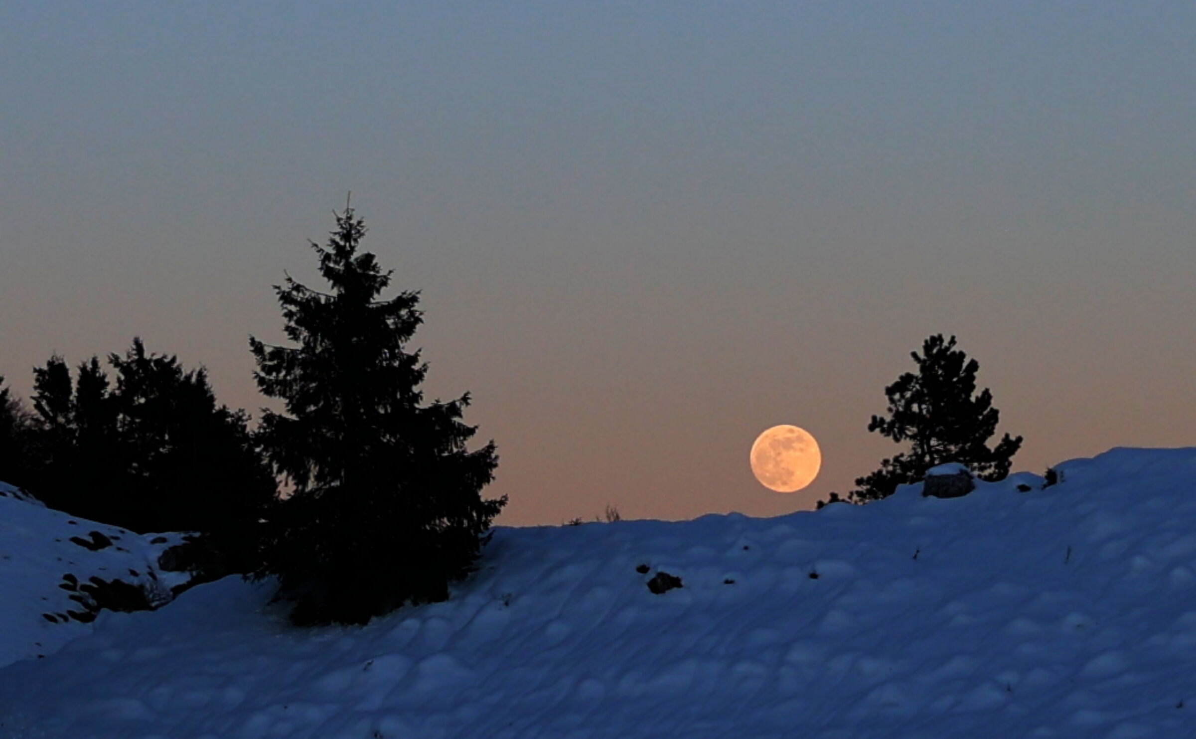 The moon rises on the mountain.