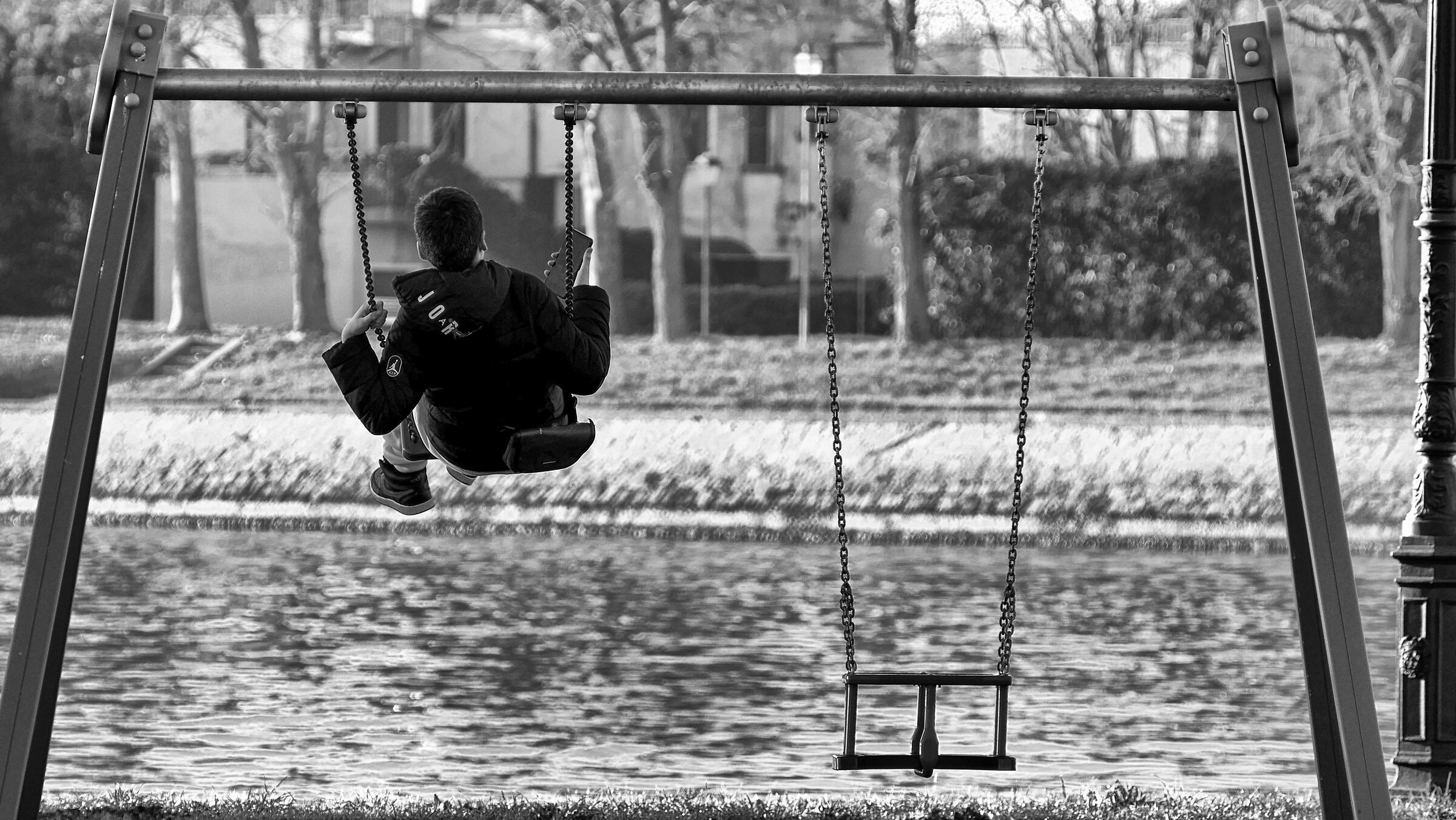 Babino on swing looks at mobile phone