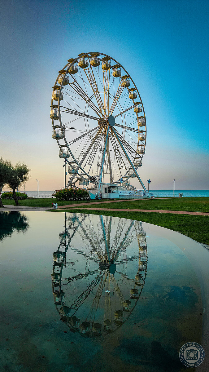Reflections of a Ferris wheel at sunset
