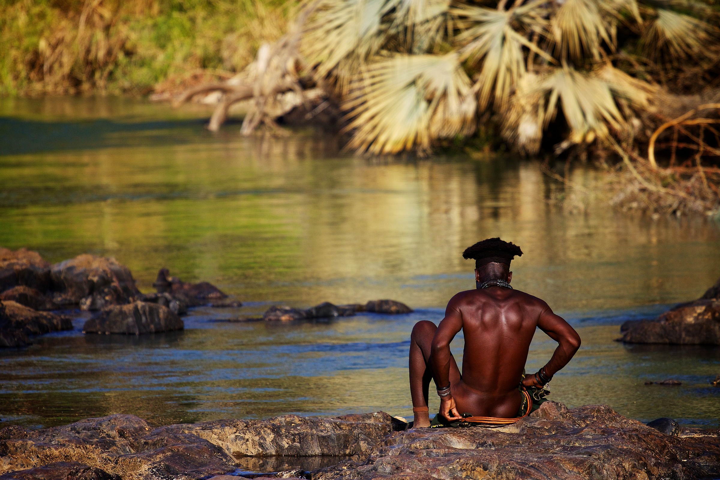 Un uomo Himba si lava alle cascate di Epupa