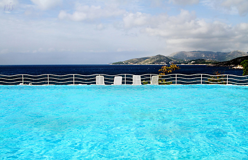 Piscina, recinto, sedie, mare, terra e cielo