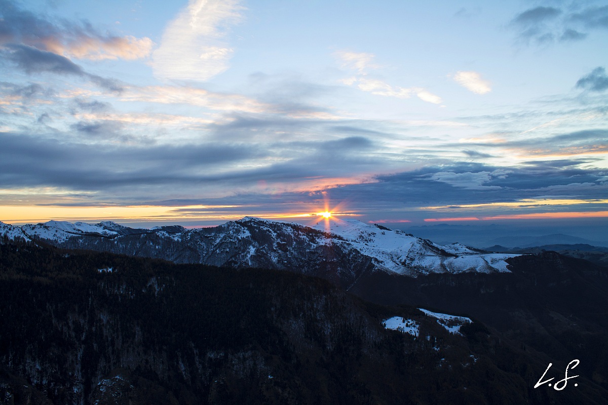 first rays of the sun between the mountains and clouds
