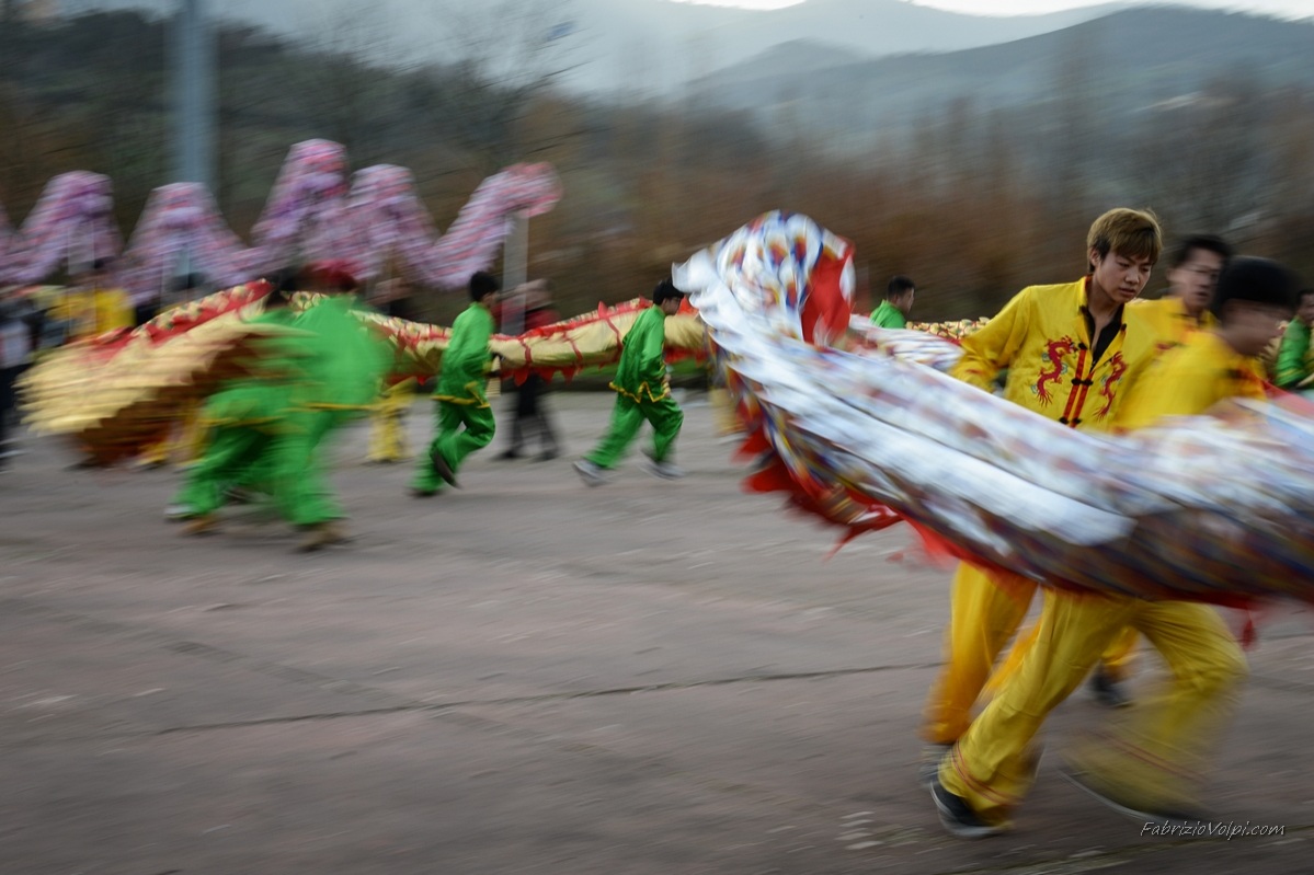 Giovani Cinesi volteggiano il Dragone per le strade