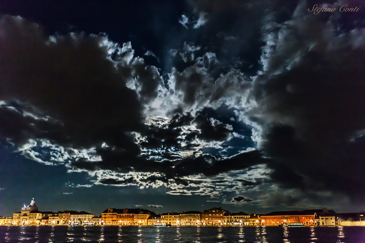 Moon shining behind the clouds from rafts