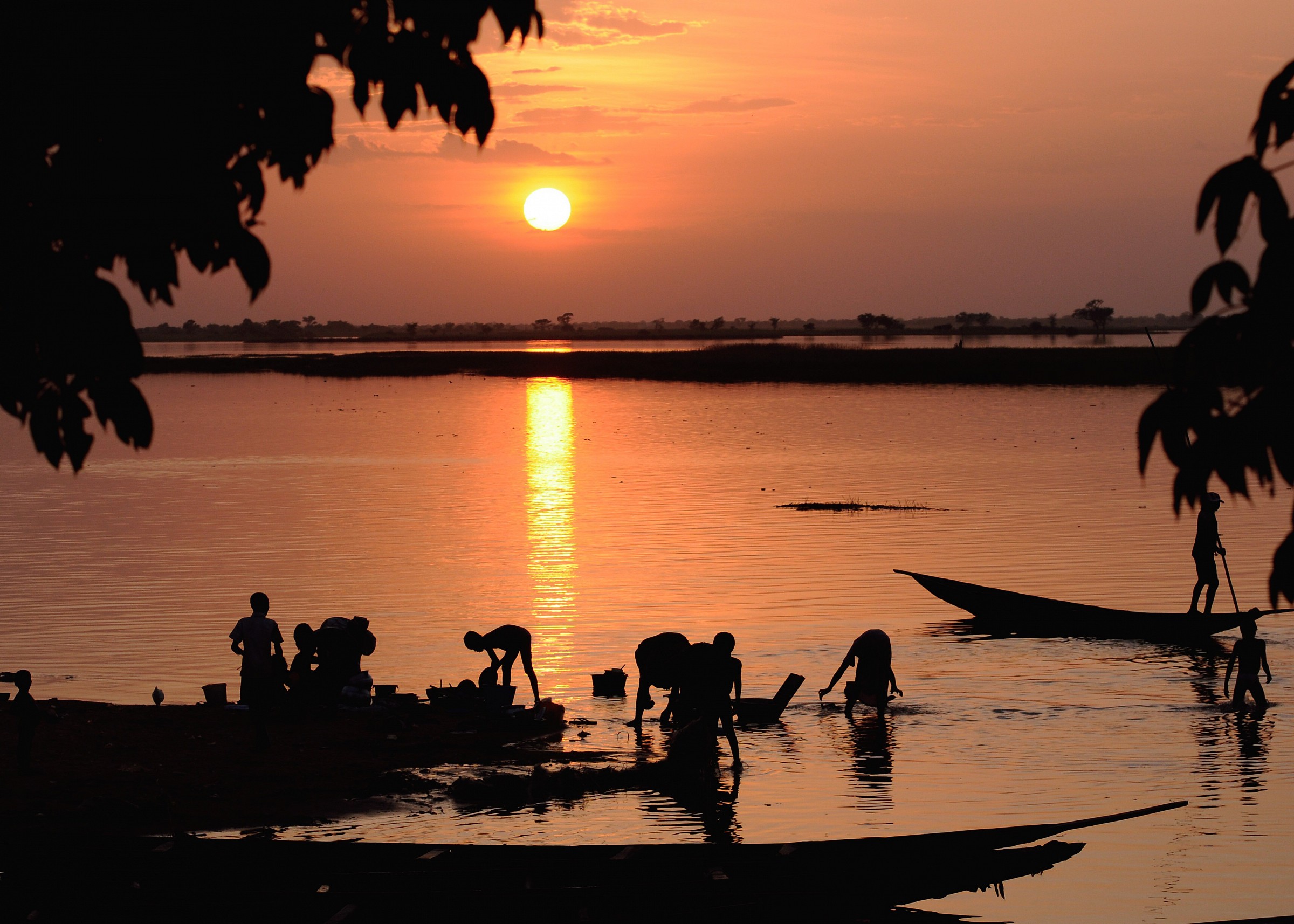 Gente operosa al tramonto sul fiume Niger